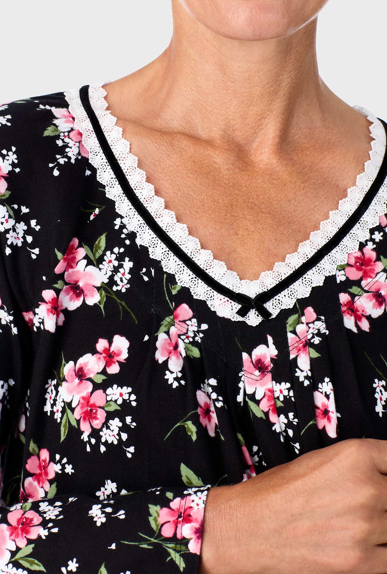 A lady wearing black long sleeve nightshirt with black floral print.