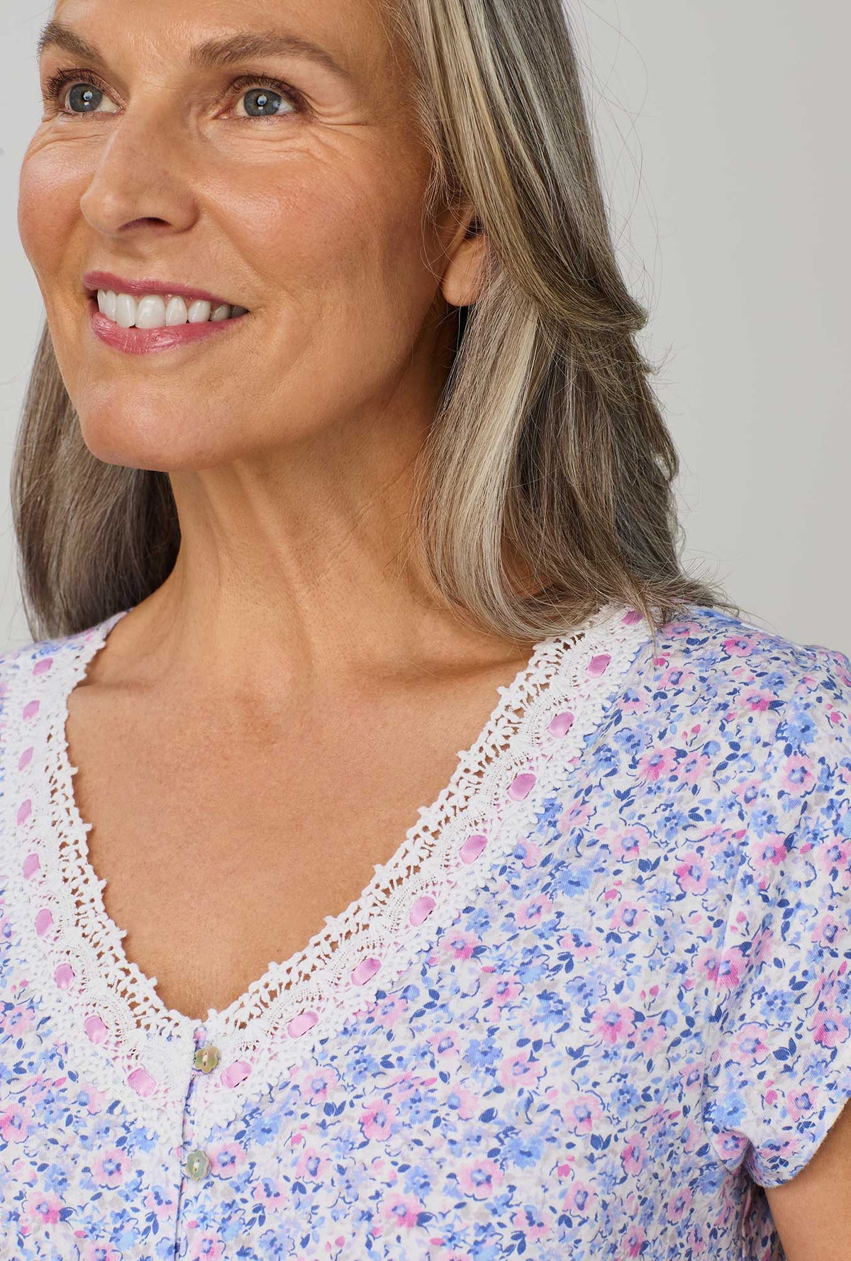 A lady wearing purple cap sleeve nightshirt with lavender and blush ditsy floral print.