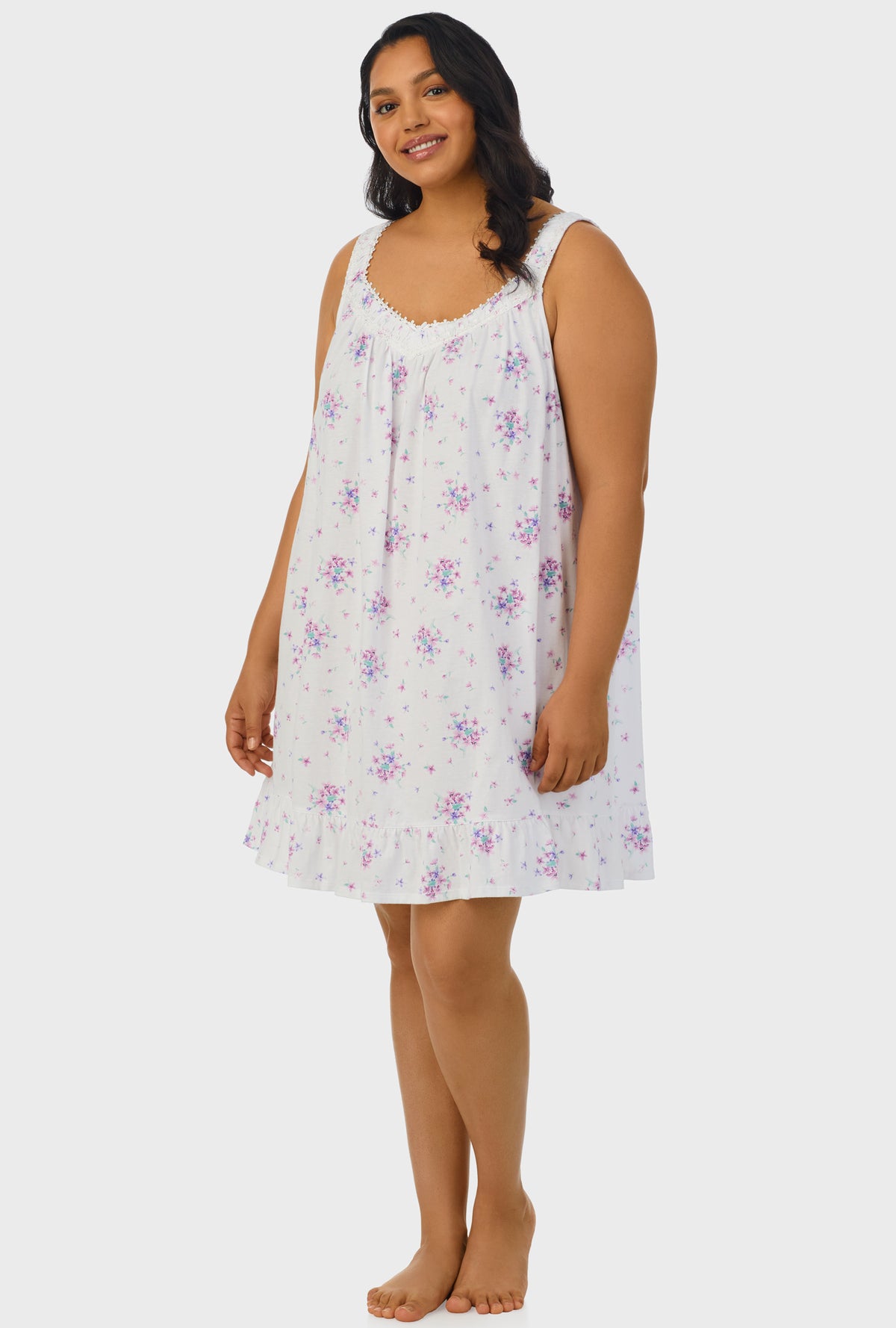 A lady wearing purple sleeveless plus size chemise with mulberry purple floral bouquet print.