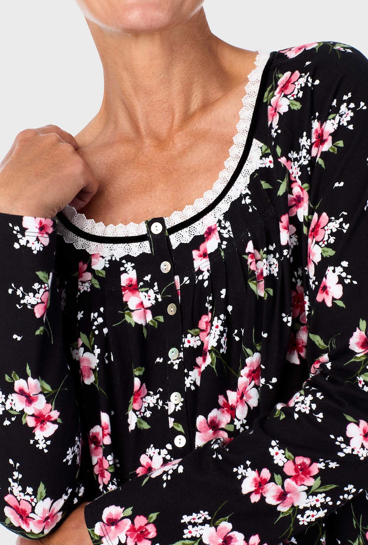 A lady wearing black long sleeve nightgown with black floral print.