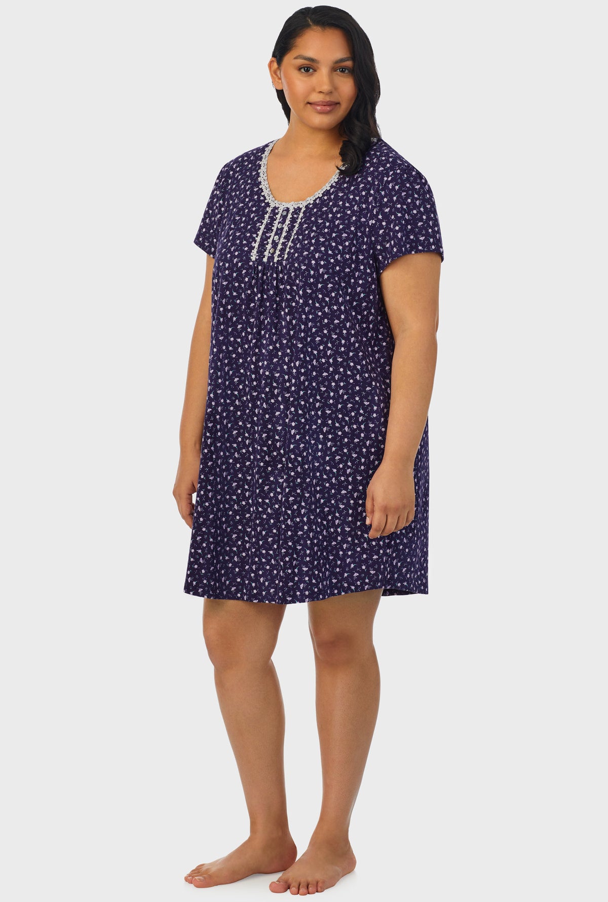 A lady wearing navy cap sleeve plus size nightshirt with midnight blue ditsy floral print.