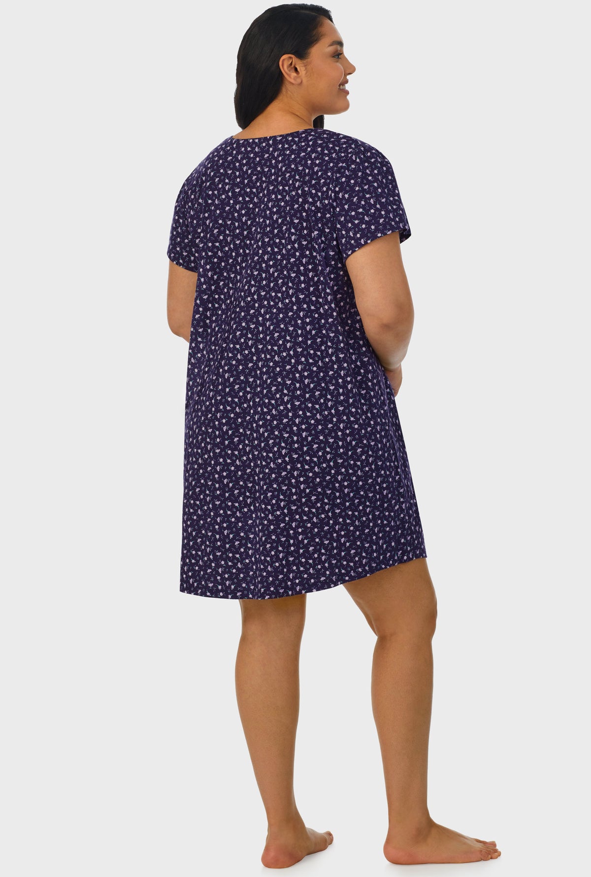 A lady wearing navy cap sleeve plus size nightshirt with midnight blue ditsy floral print.