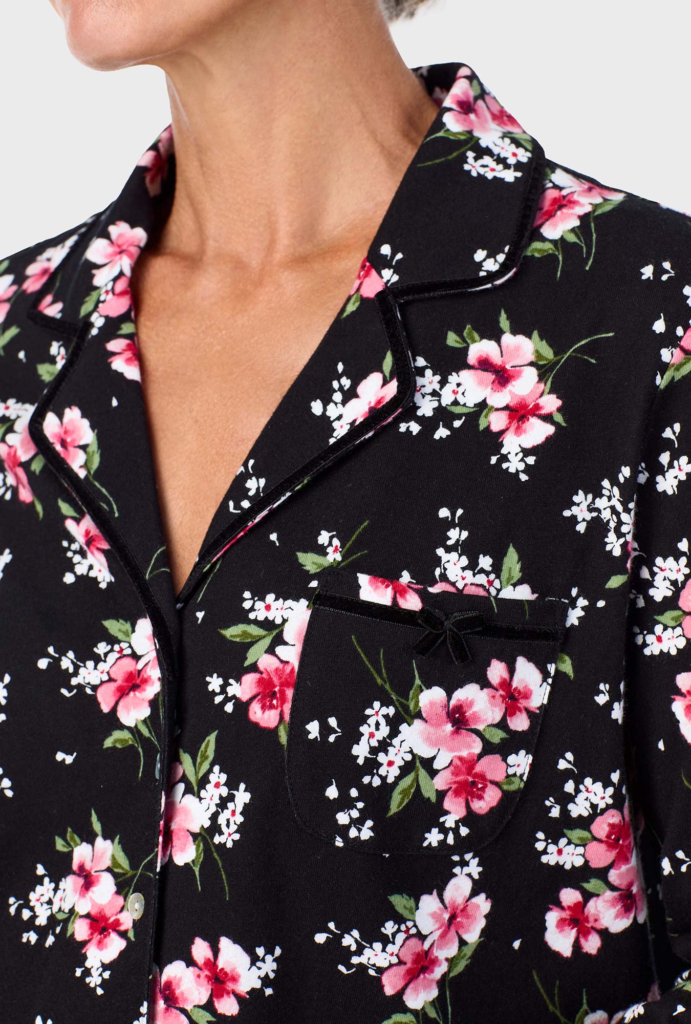 A lady wearing black long sleeve pj set with black floral print.