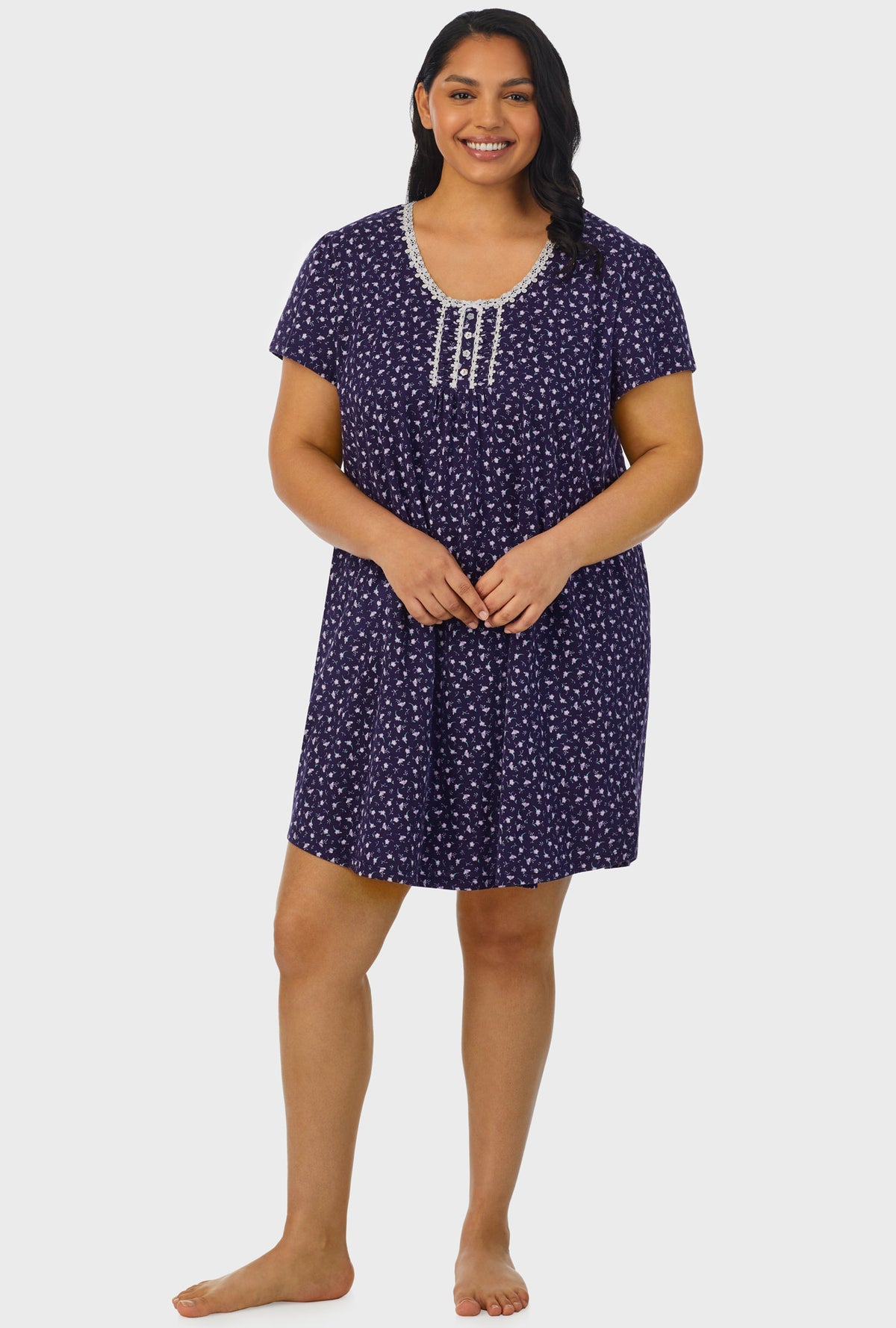 A lady wearing navy cap sleeve plus size nightshirt with midnight blue ditsy floral print.