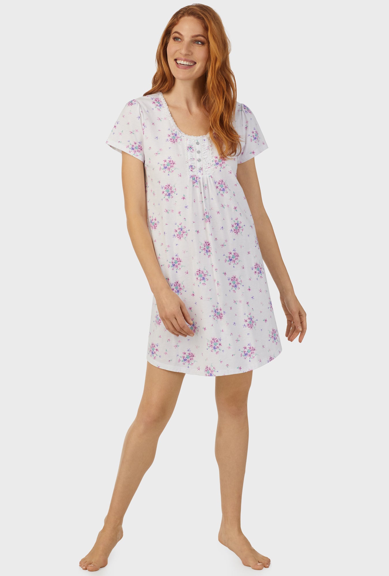 A lady wearing white cap sleeve nightshirt  with mulberry purple floral print bouquet.