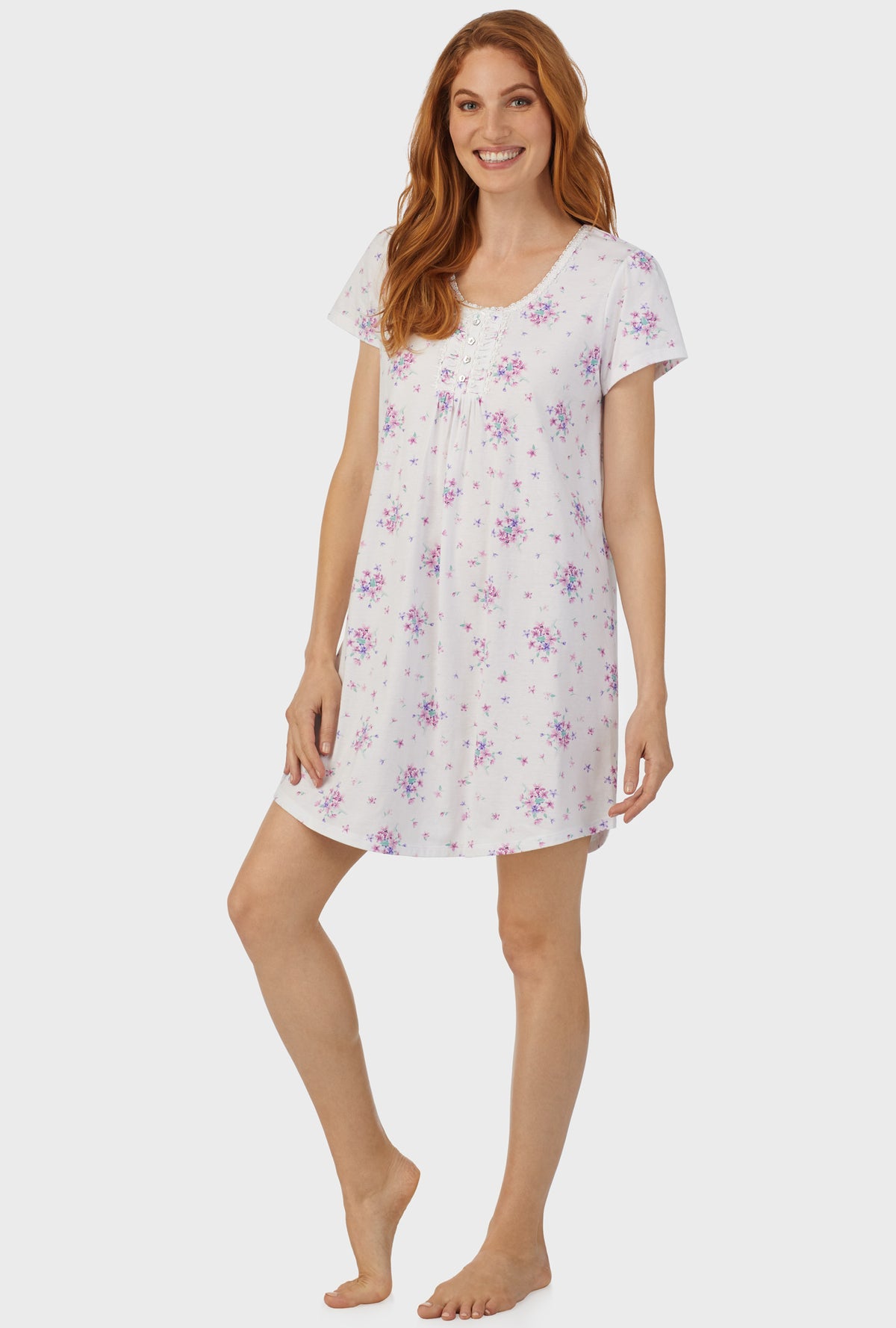 A lady wearing white cap sleeve nightshirt  with mulberry purple floral print bouquet.