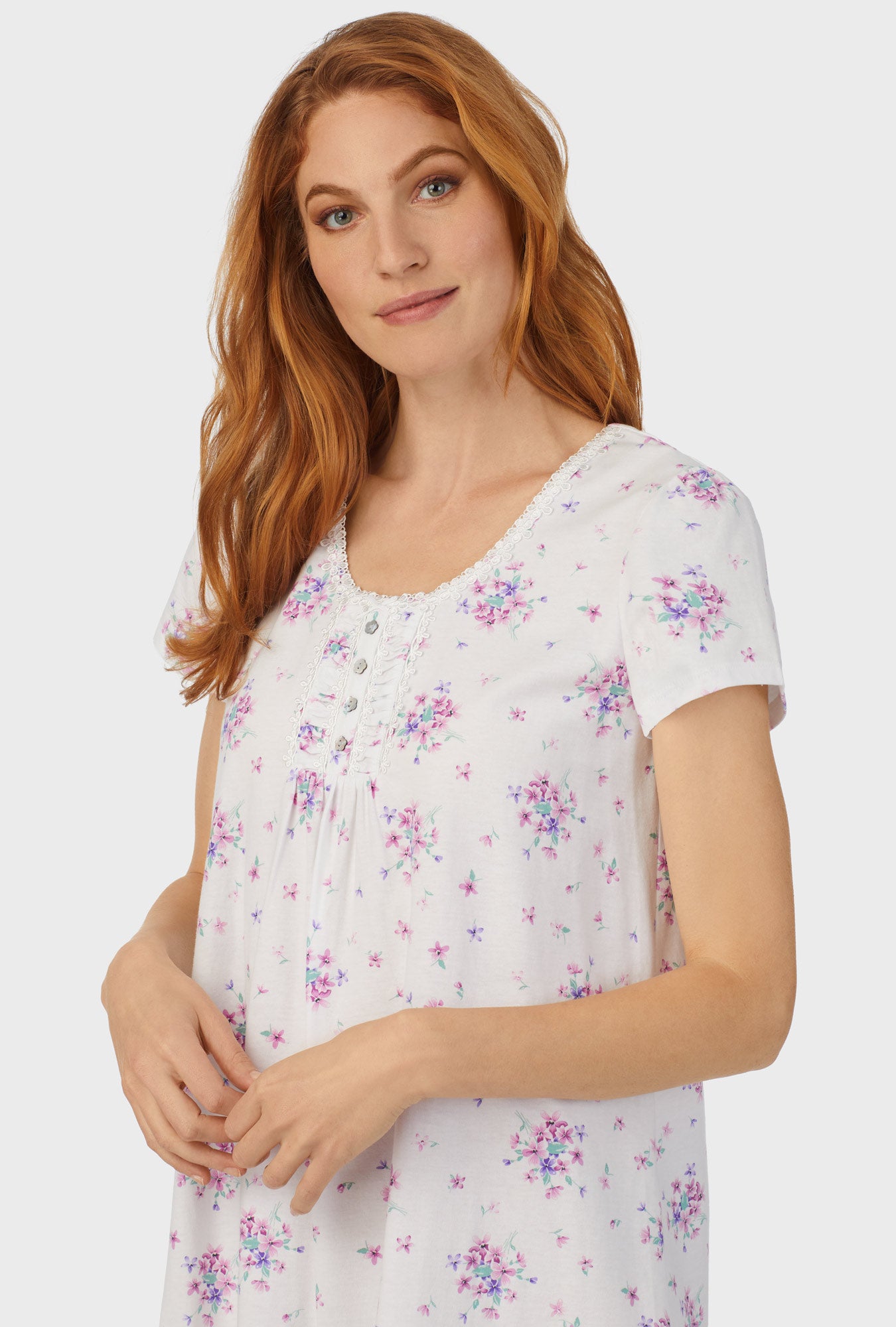 A lady wearing white cap sleeve nightshirt  with mulberry purple floral print bouquet.