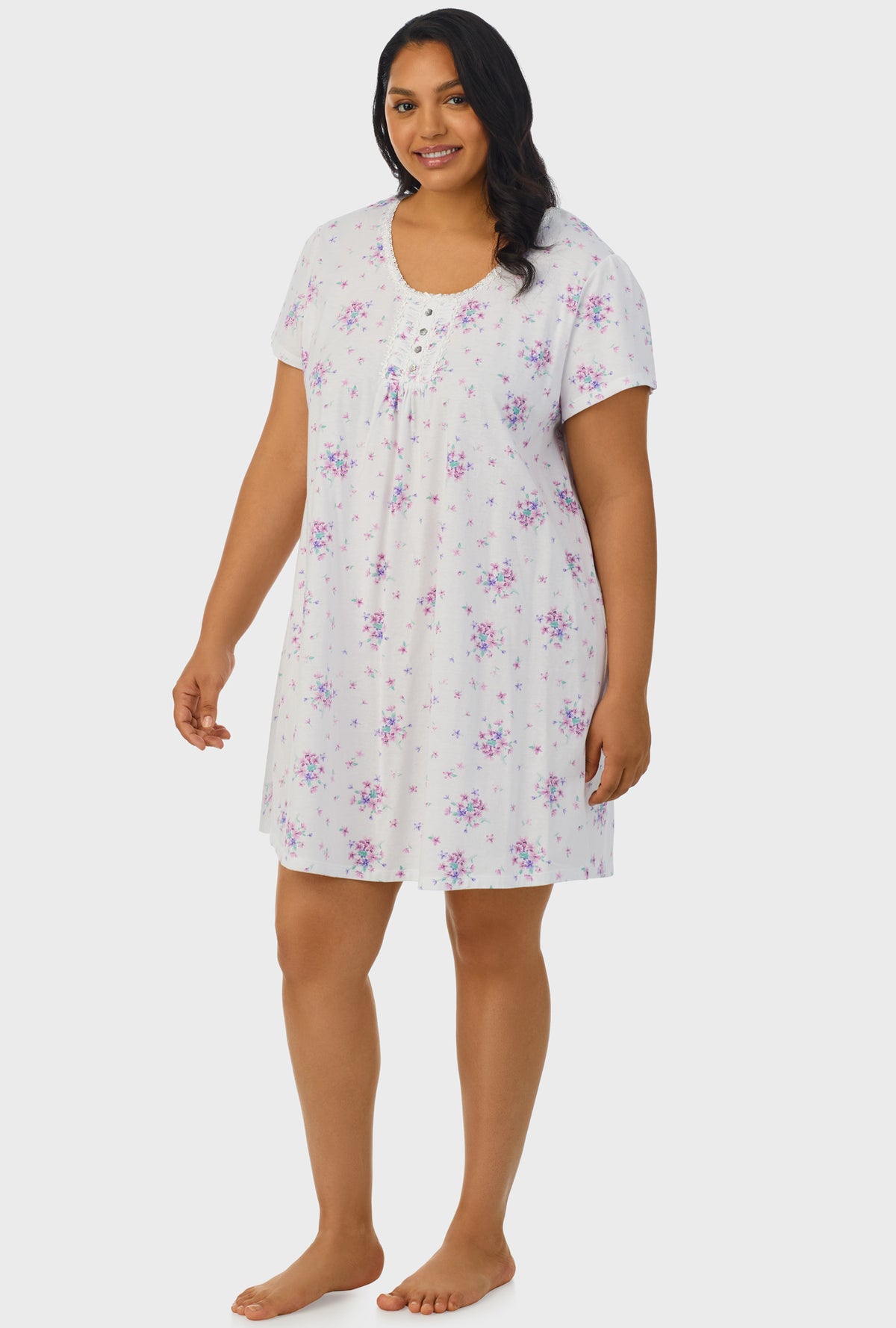 A lady wearing white cap sleeve plus size nightshirt with mulberry purple floral print bouquet.