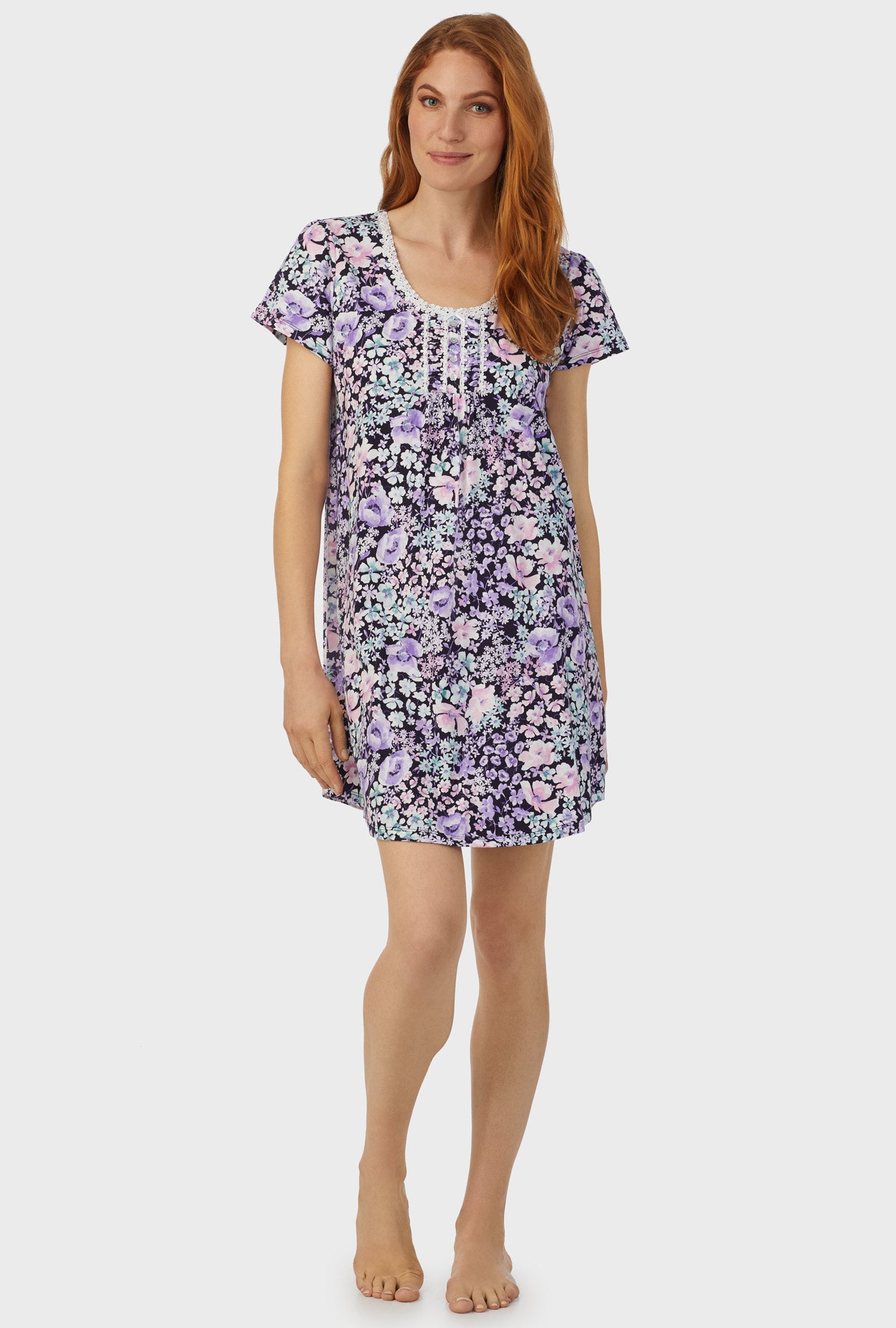 A lady wearing navy floral cap sleeve nightshirt with midnight blue floral print.