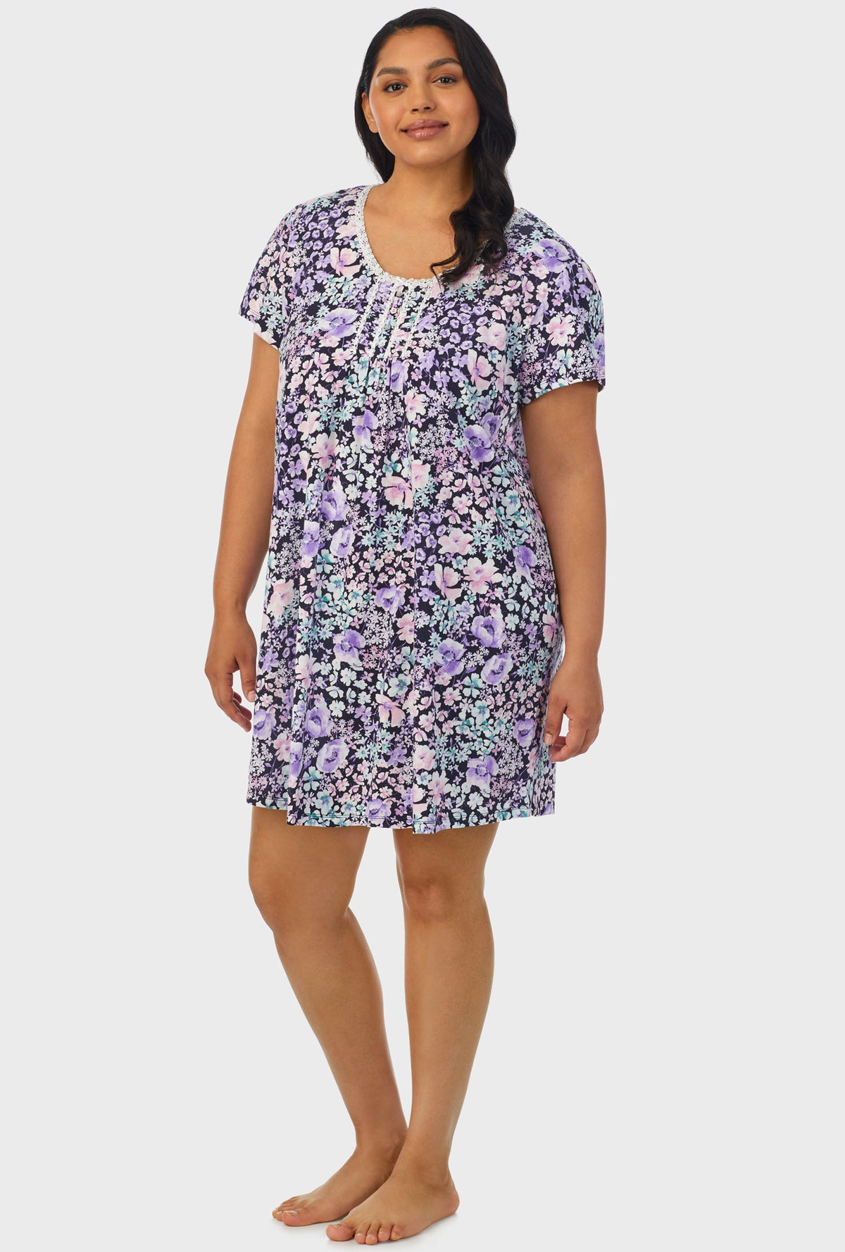 A lady wearing navy floral cap sleeve plus size nightshirt with midnight blue floral print.