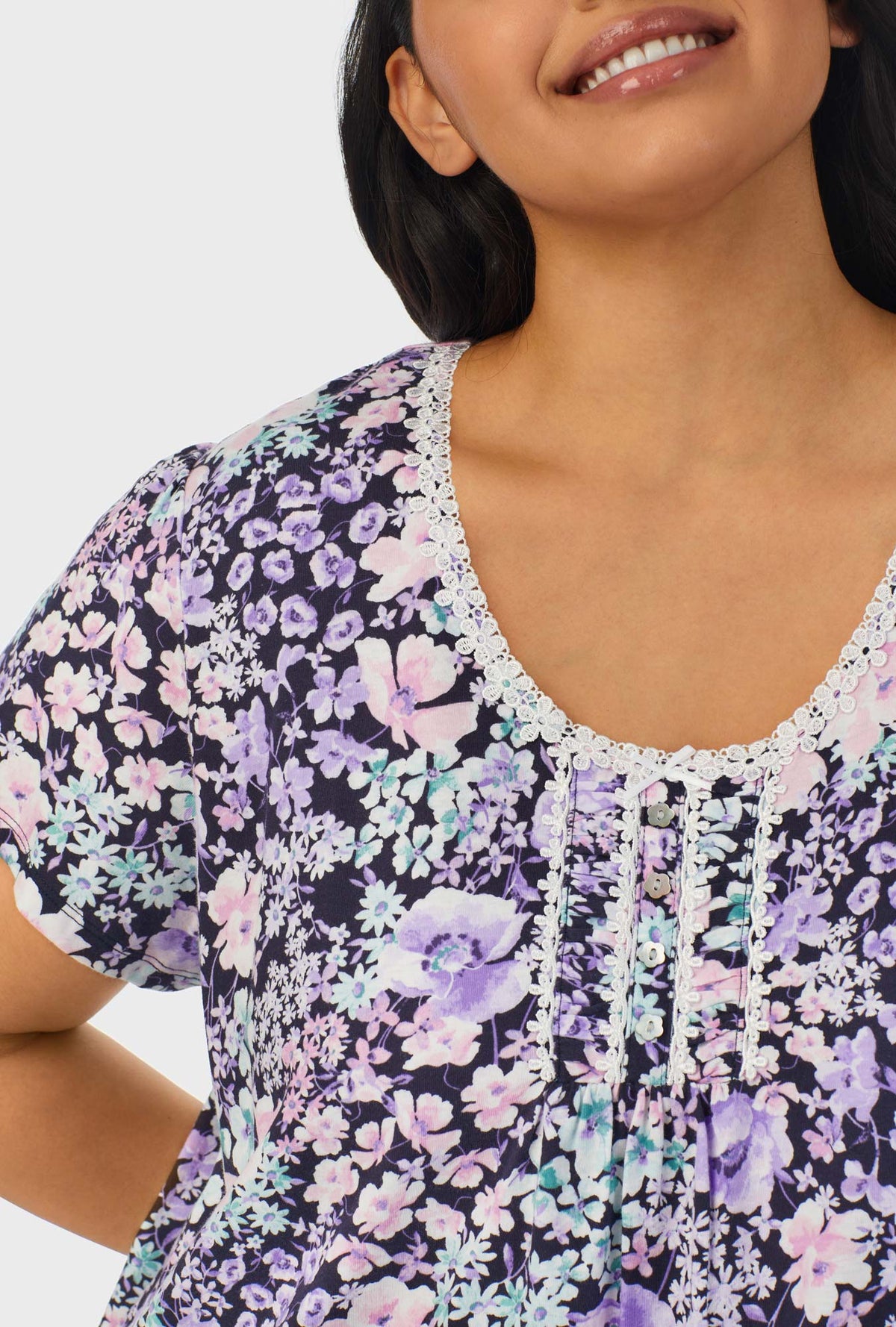 A lady wearing navy floral cap sleeve plus size nightshirt with midnight blue floral print.