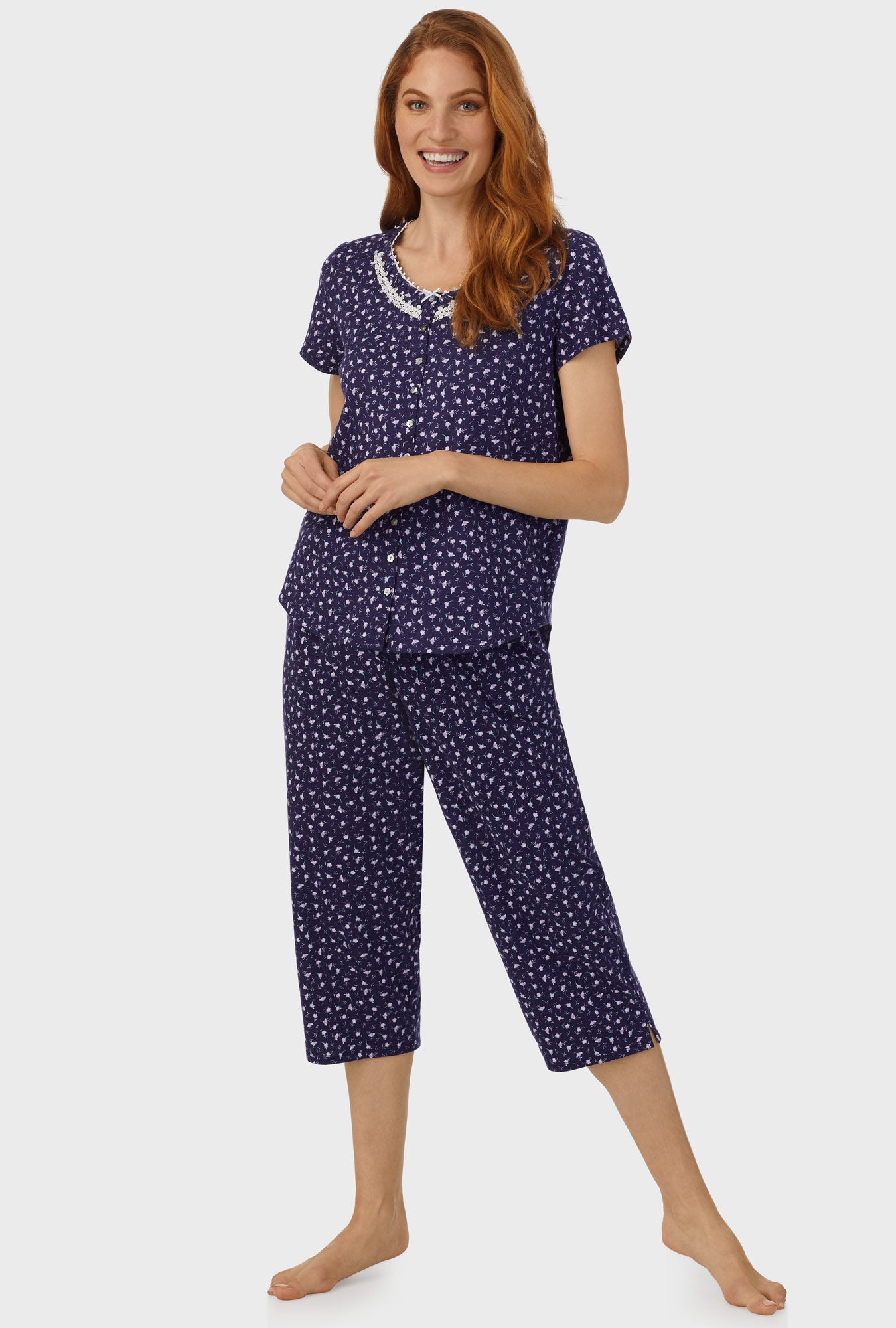 A lady wearing navy short sleeve capri pant pj set with midnight blue ditsy floral print.