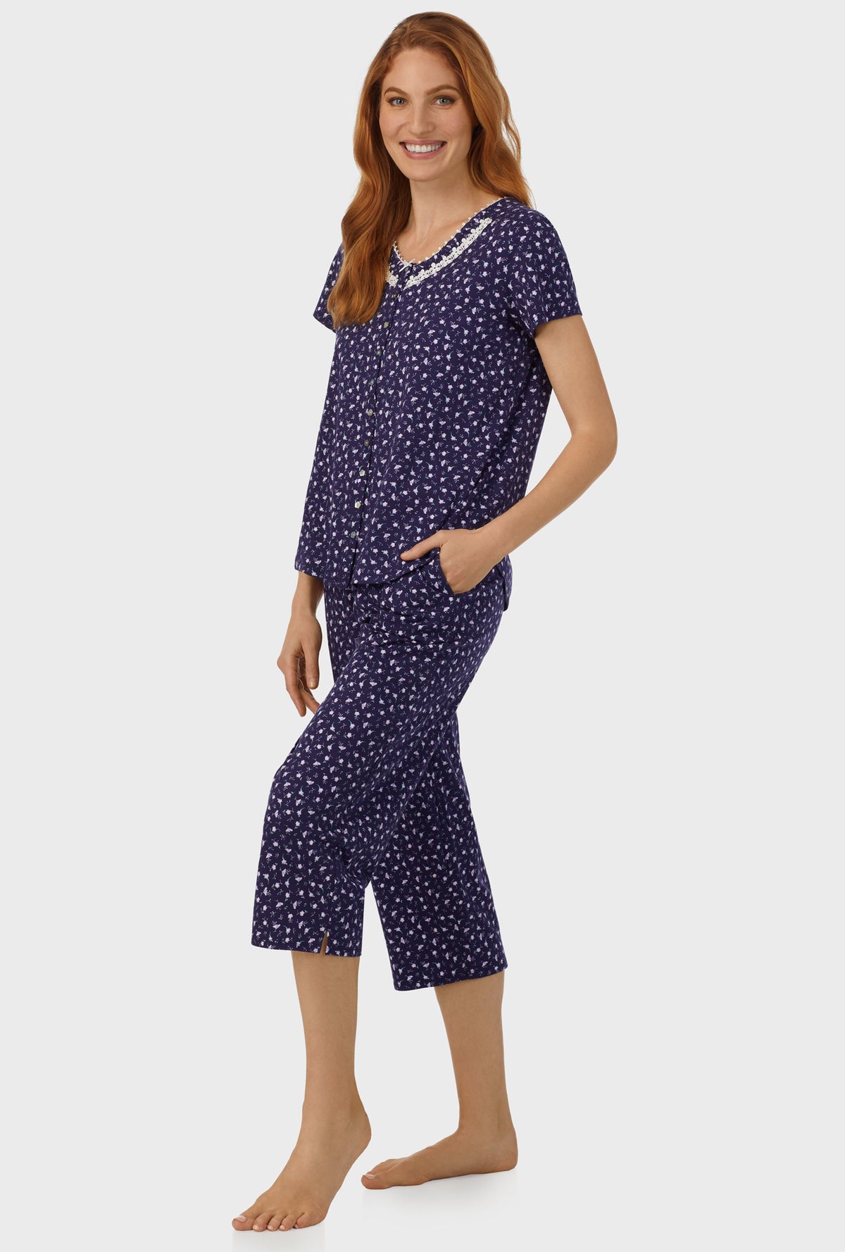 A lady wearing navy short sleeve capri pant pj set with midnight blue ditsy floral print.