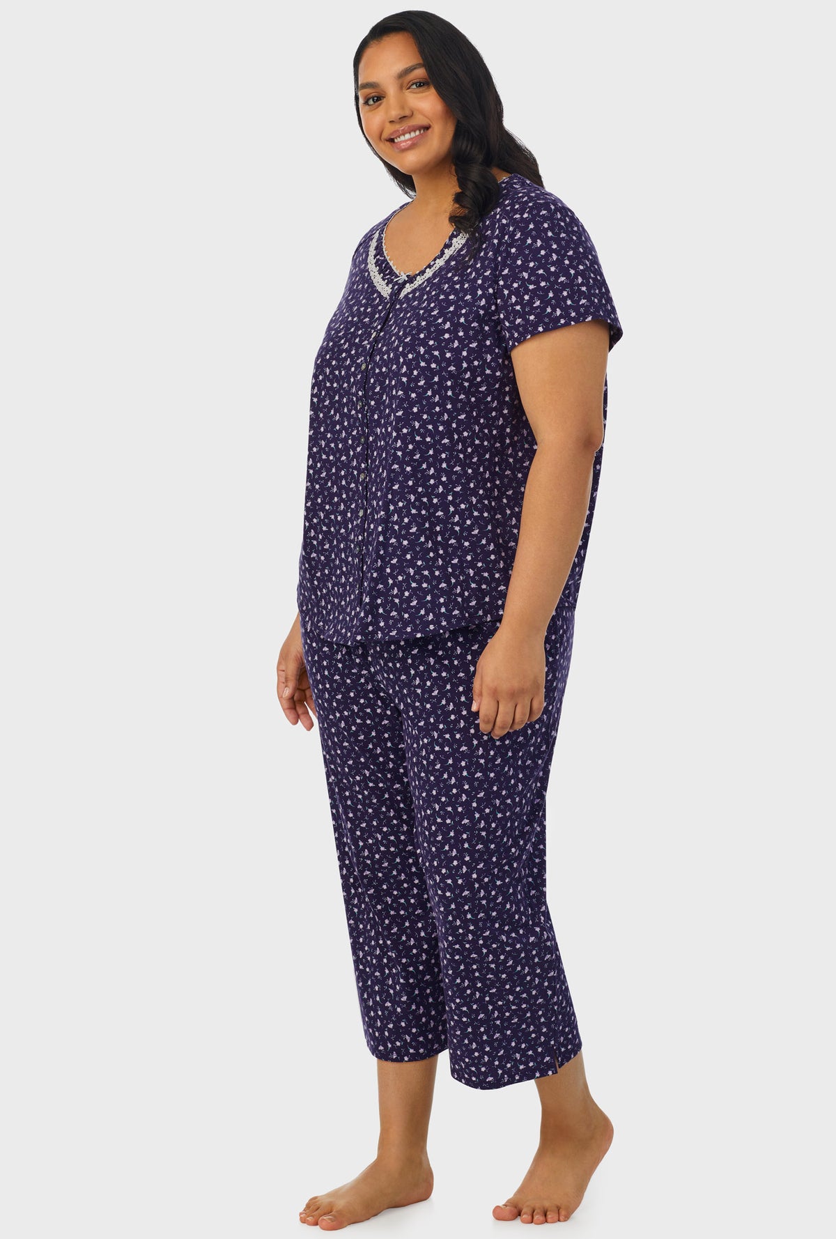 A lady wearing navy short sleeve capri plus size pant pj set with midnight blue ditsy floral print.