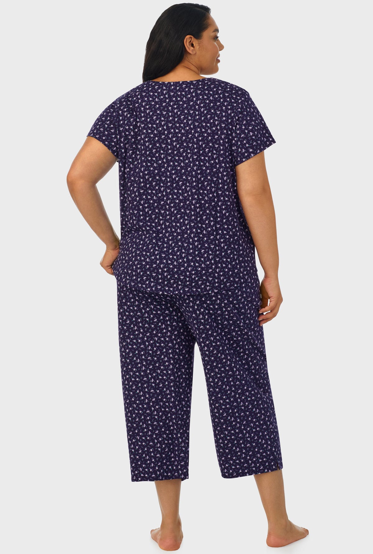 A lady wearing navy short sleeve capri plus size pant pj set with midnight blue ditsy floral print.