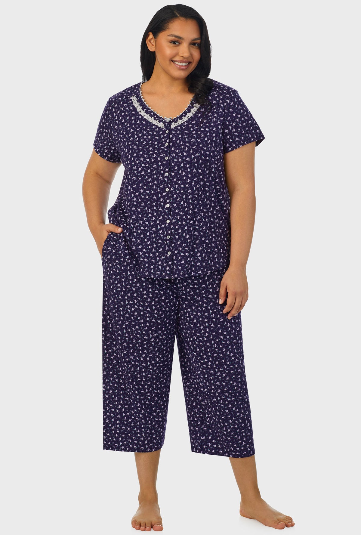 A lady wearing navy short sleeve capri plus size pant pj set with midnight blue ditsy floral print.