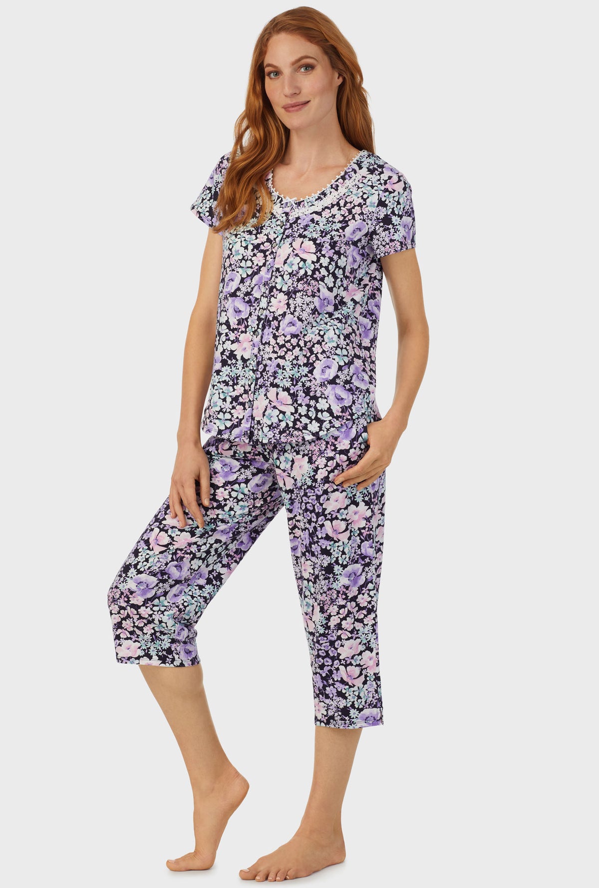 A lady wearing navy short sleeve capri pant pj set  with midnight blue floral print.