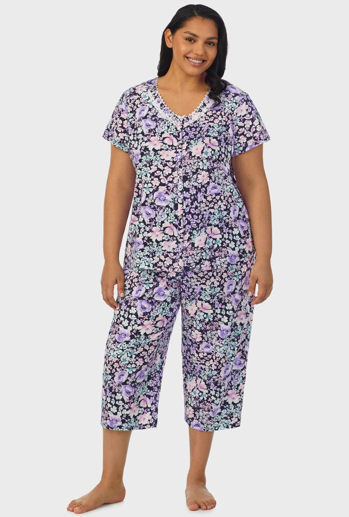 A lady wearing navy short sleeve capri pant plus size pj set with midnight blue floral print.