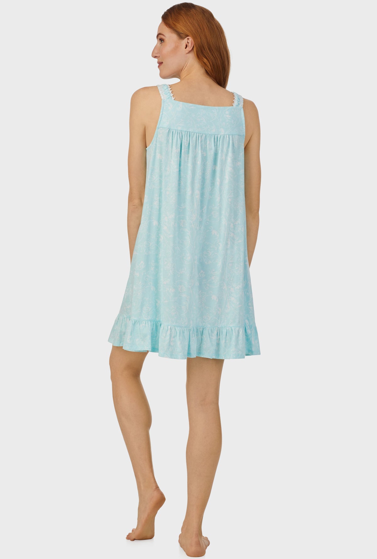 A lady wearing aqua sleeveless chemise with scroll print.