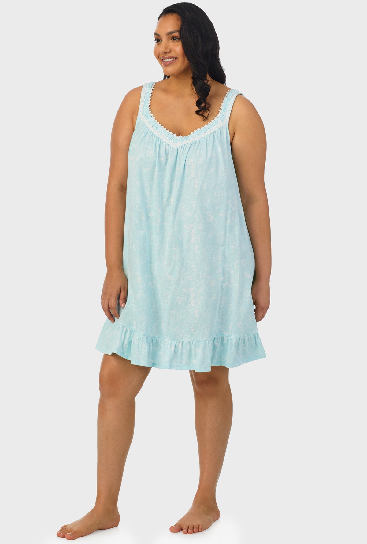 A lady wearing aqua sleeveless plus size chemise with scroll print.