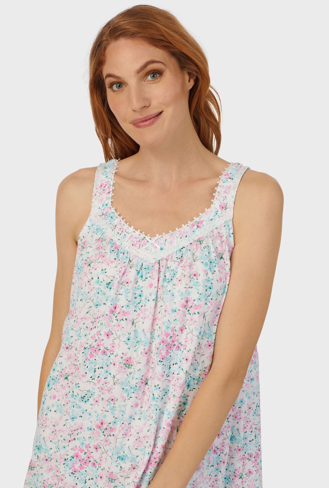 A lady wearing multi color sleeveless chemise with aqua and pink floral print.