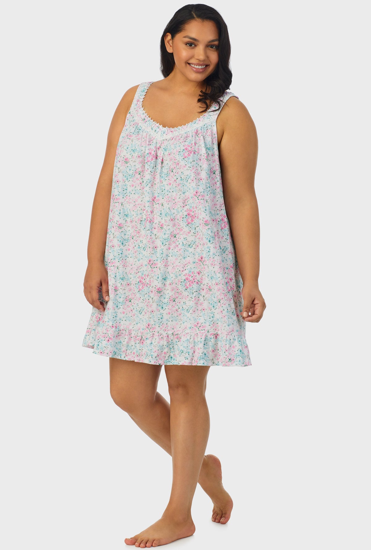 A lady wearing multi color sleeveless plus size chemise with aqua and pink floral print.