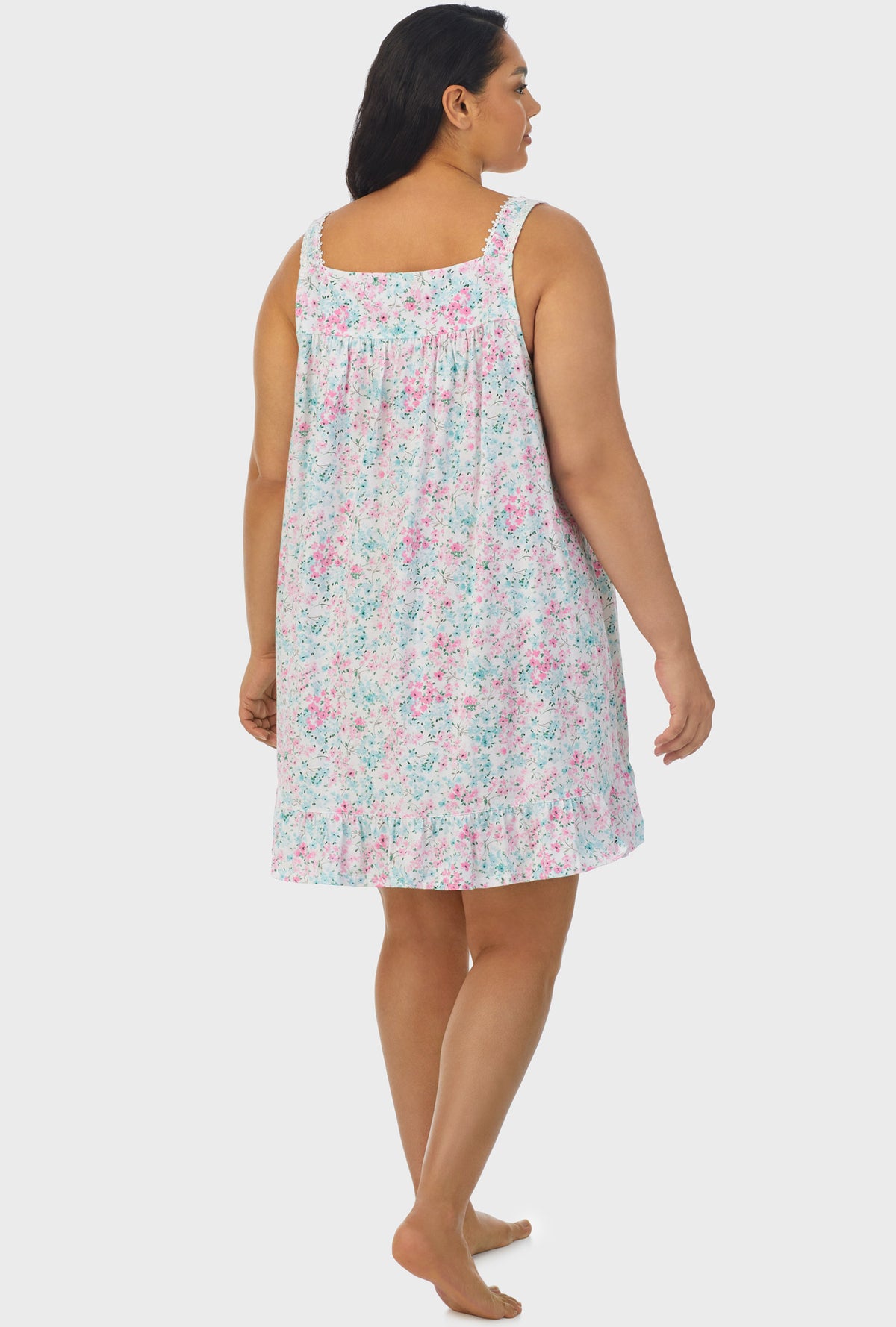 A lady wearing multi color sleeveless plus size chemise with aqua and pink floral print.