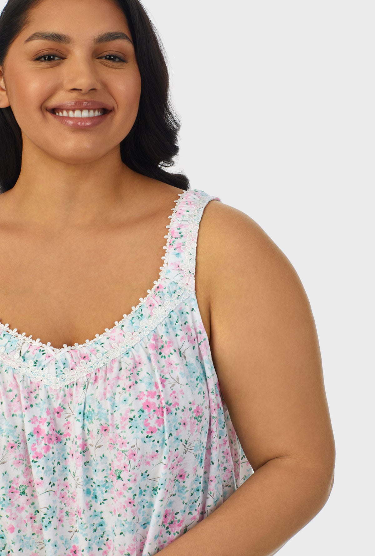 A lady wearing multi color sleeveless plus size chemise with aqua and pink floral print.