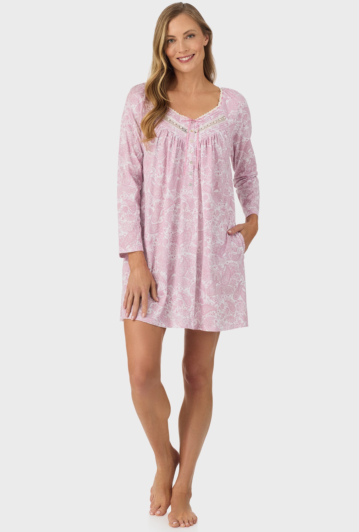 A lady wearing pink long sleeve nightgown with pink paisley print.