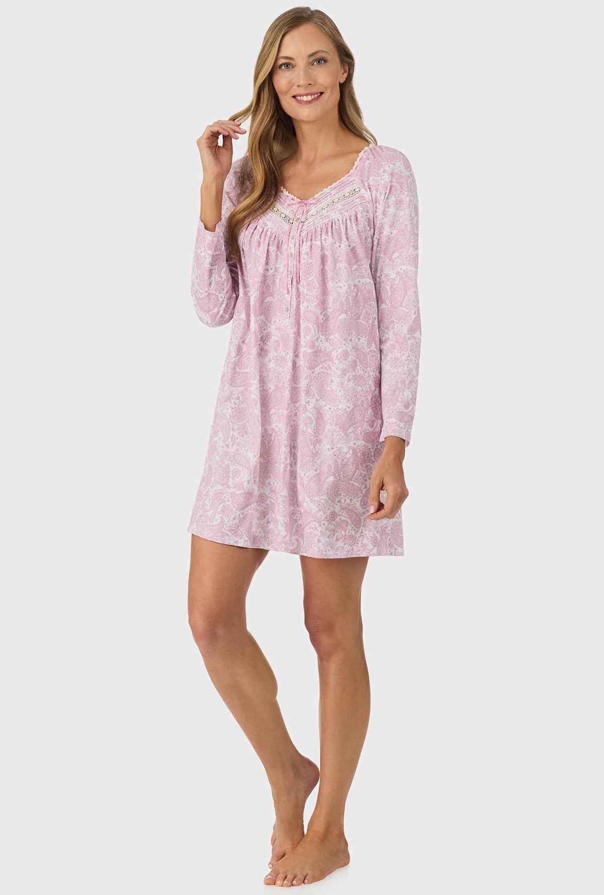 A lady wearing pink long sleeve nightgown with pink paisley print.