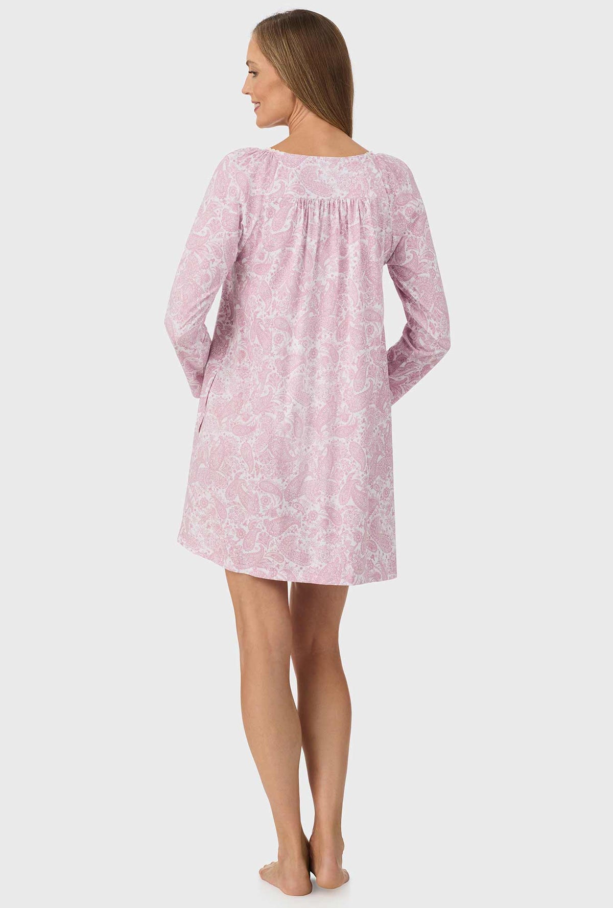 A lady wearing pink long sleeve nightgown with pink paisley print.