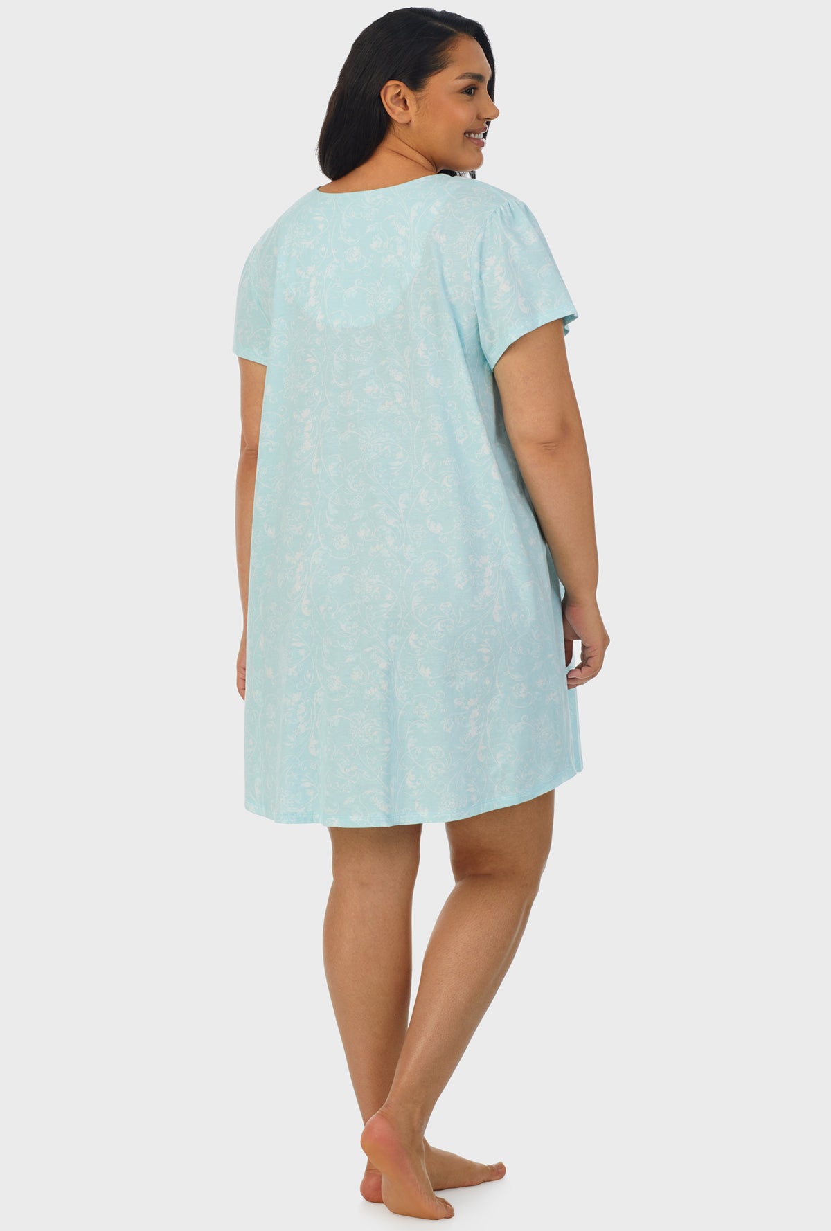 A lady wearing blue cap sleeve plus size nightshirt with aqua scroll print.