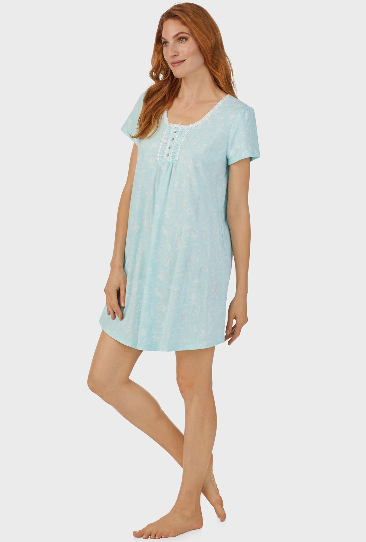 A lady wearing blue cap sleeve nightshirt with aqua scroll print.