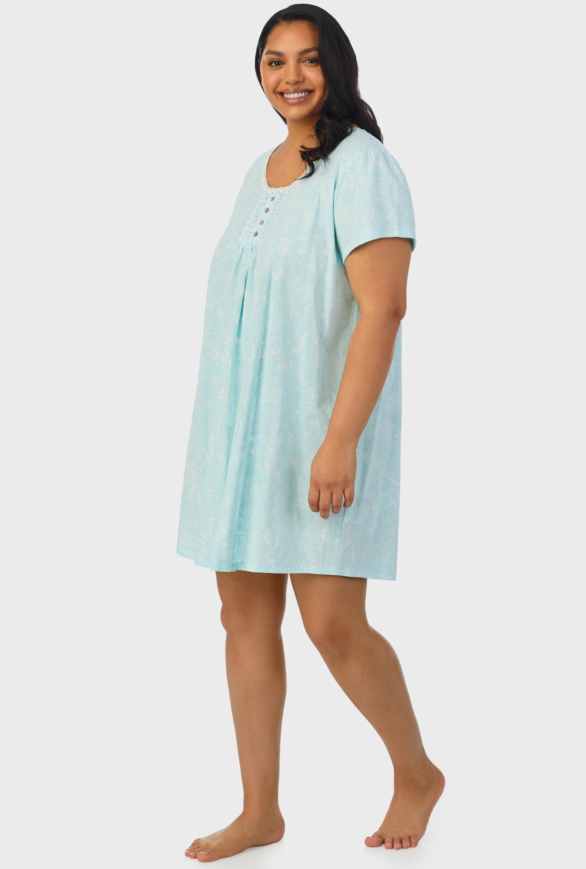 A lady wearing blue cap sleeve plus size nightshirt with aqua scroll print.