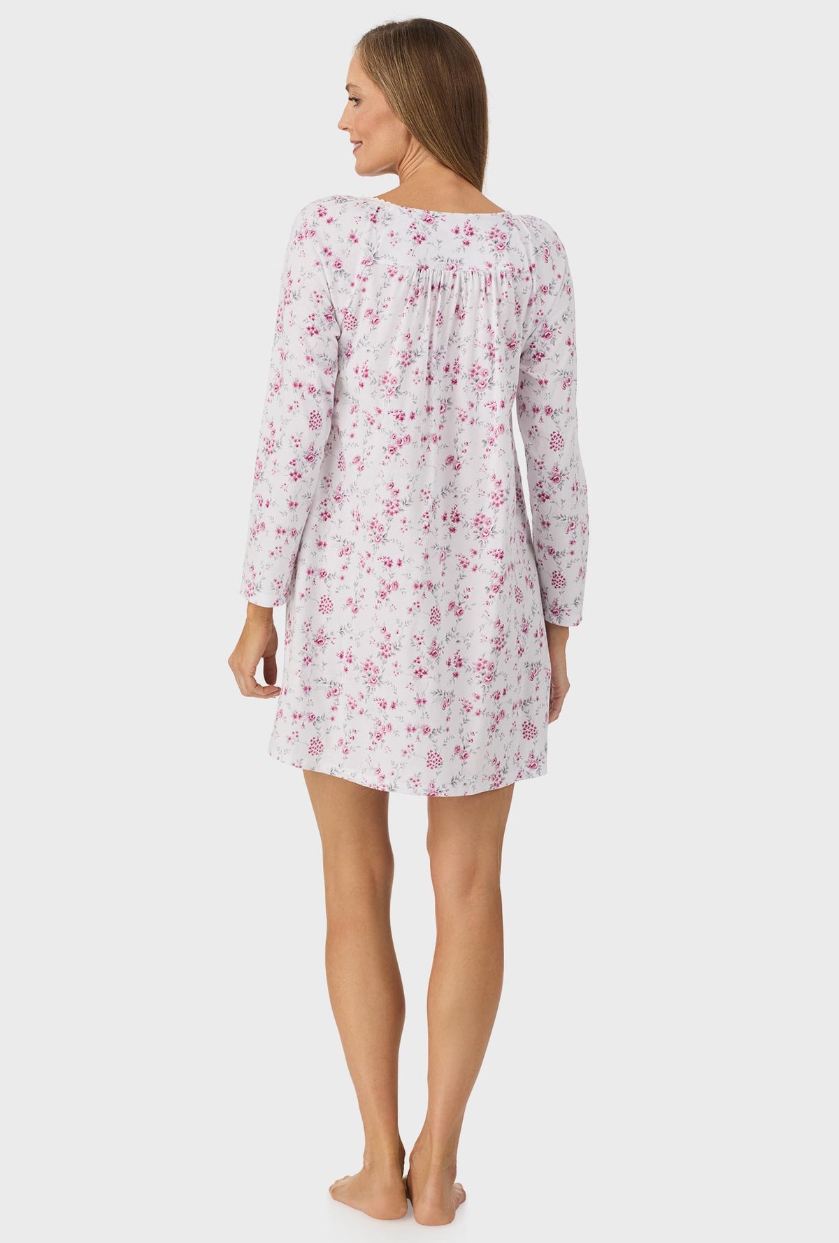 A lady wearing pink long sleeve nightgown with pink floral print.