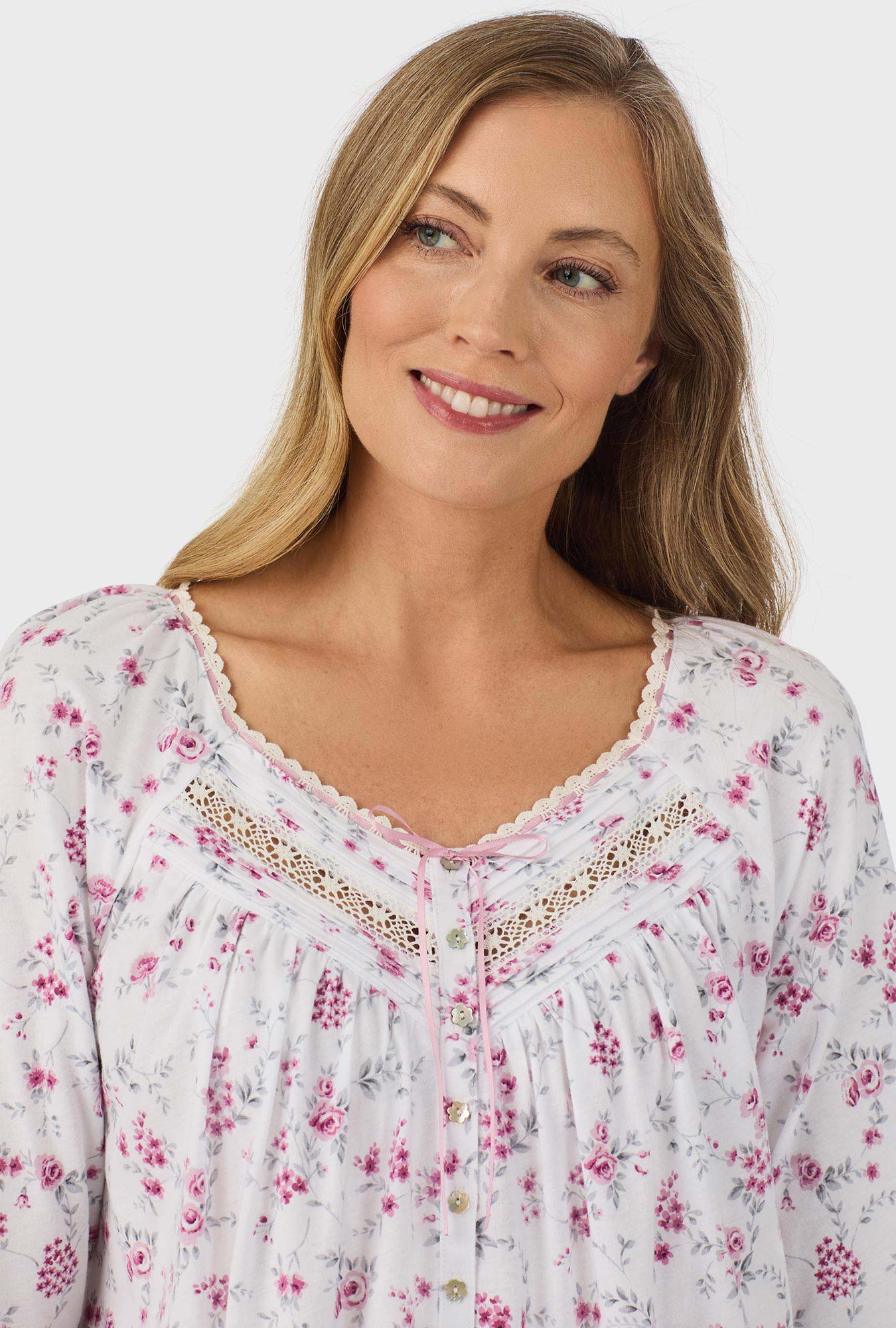 A lady wearing pink long sleeve nightgown with pink floral print.