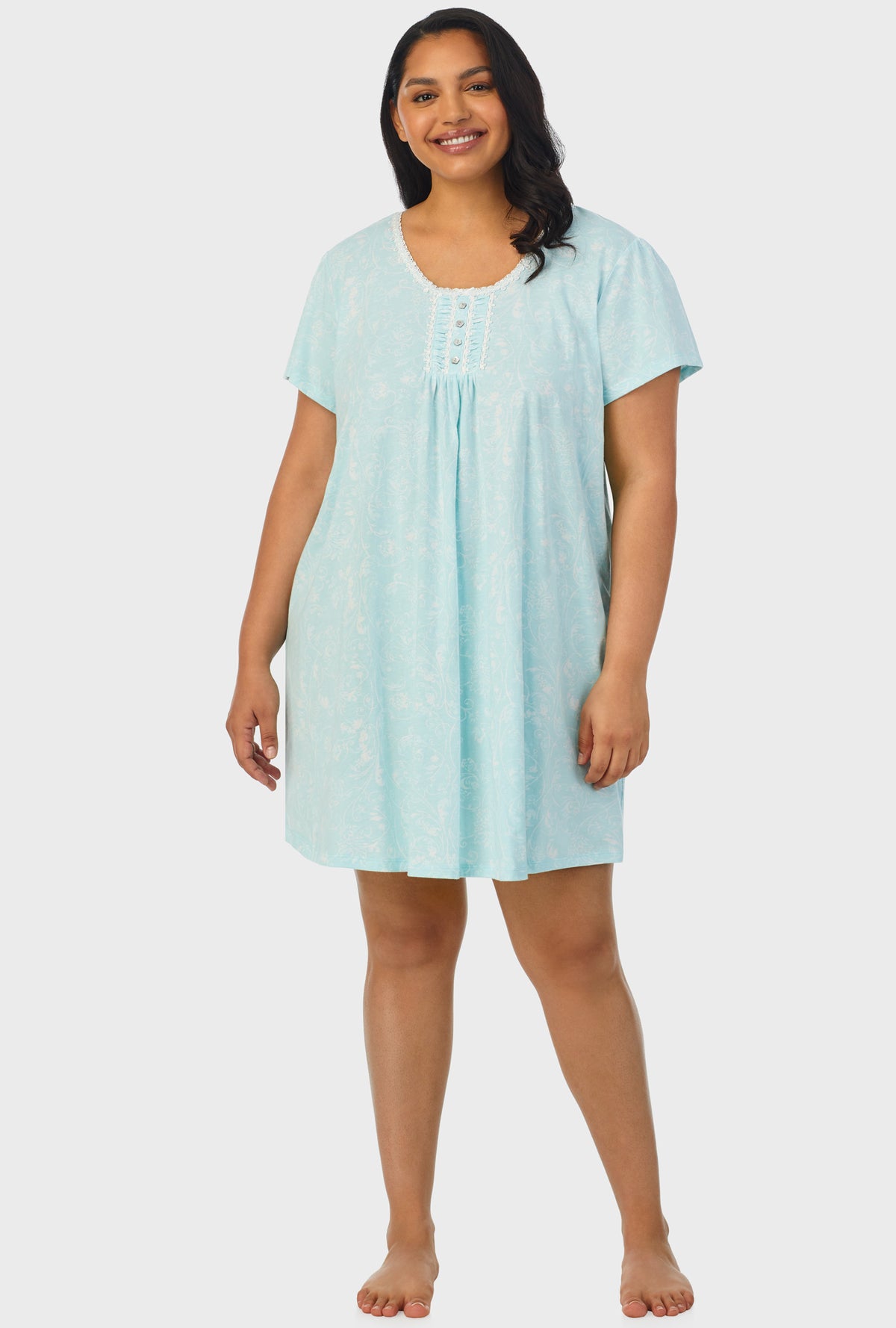 A lady wearing blue cap sleeve plus size nightshirt with aqua scroll print.