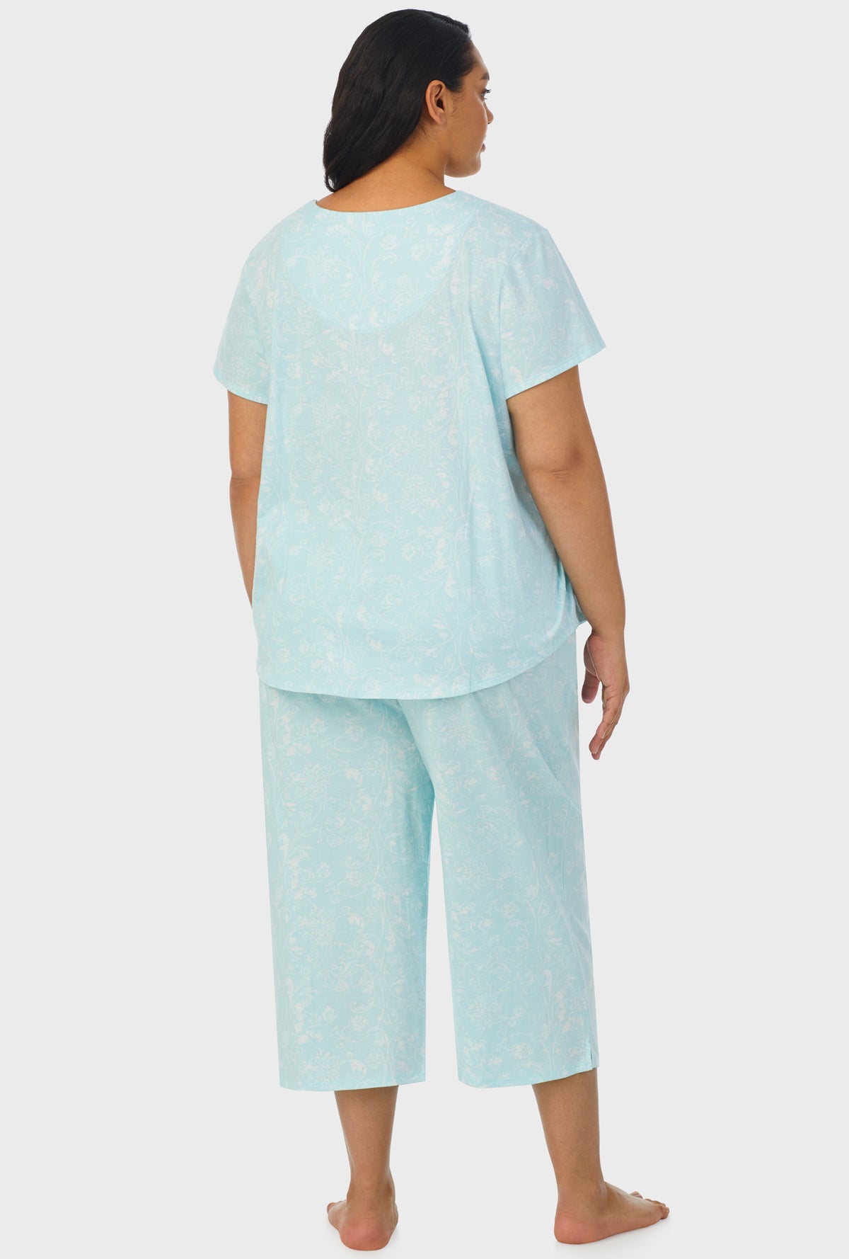 A lady wearing aqua short sleeve capri plus size pant pj set with scroll print.