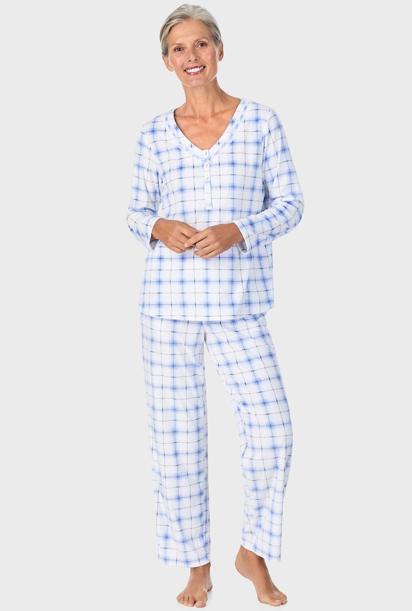 A lady wearing blue long sleeve Henley  pj set with blue bell plaid print.