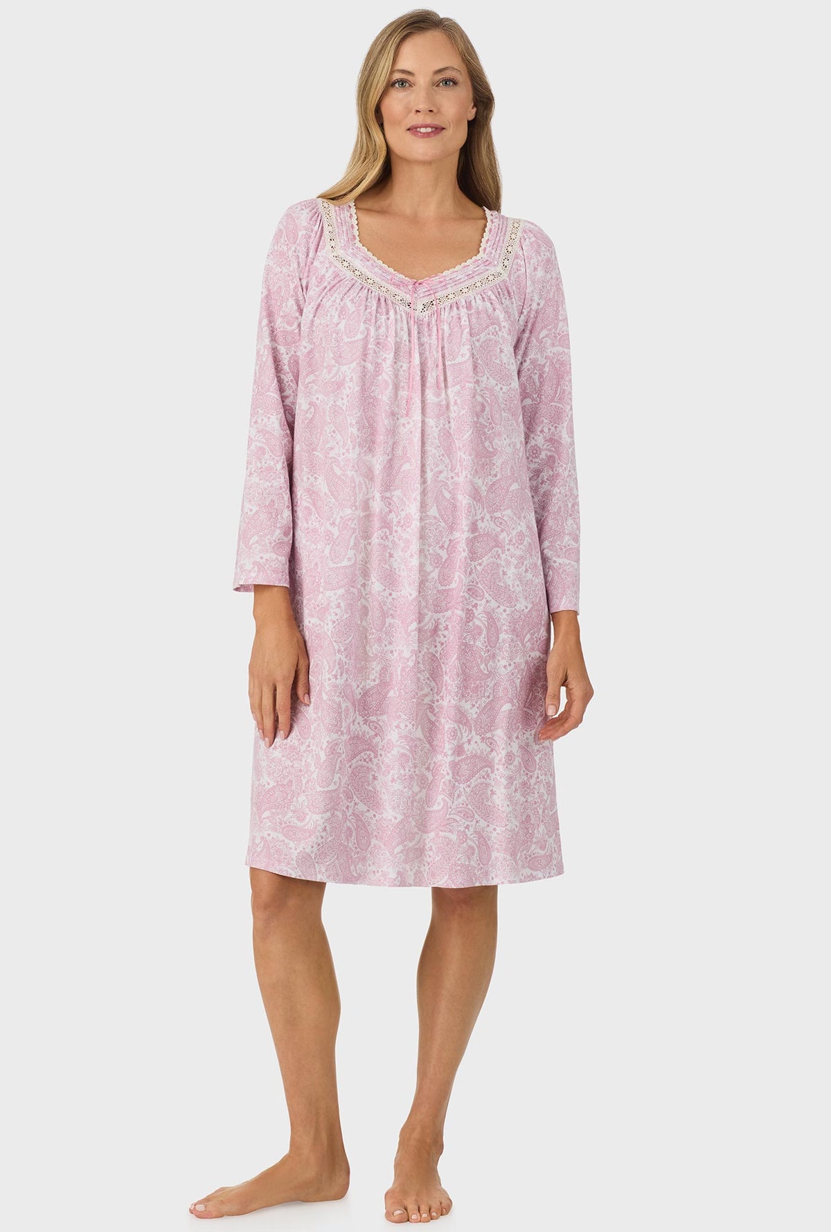 A lady wearing pink long sleeve nightgown with pink paisley print.