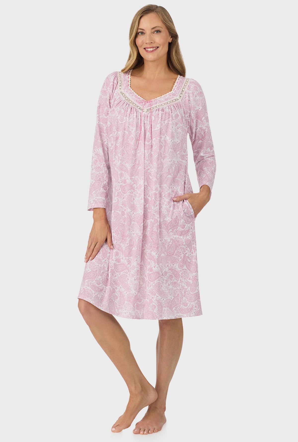 A lady wearing pink long sleeve nightgown with pink paisley print.