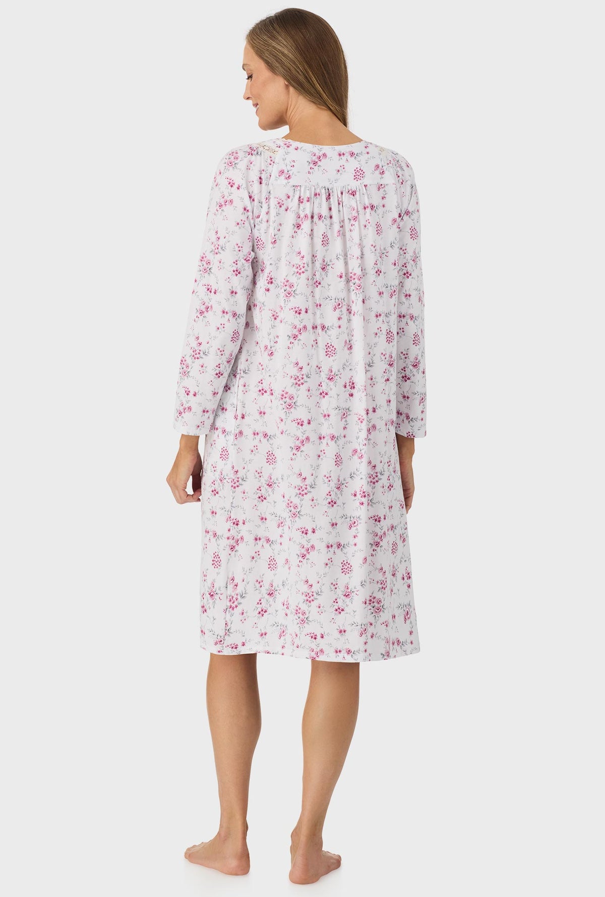 A lady wearing pink long sleeve nightgown with pink floral print.