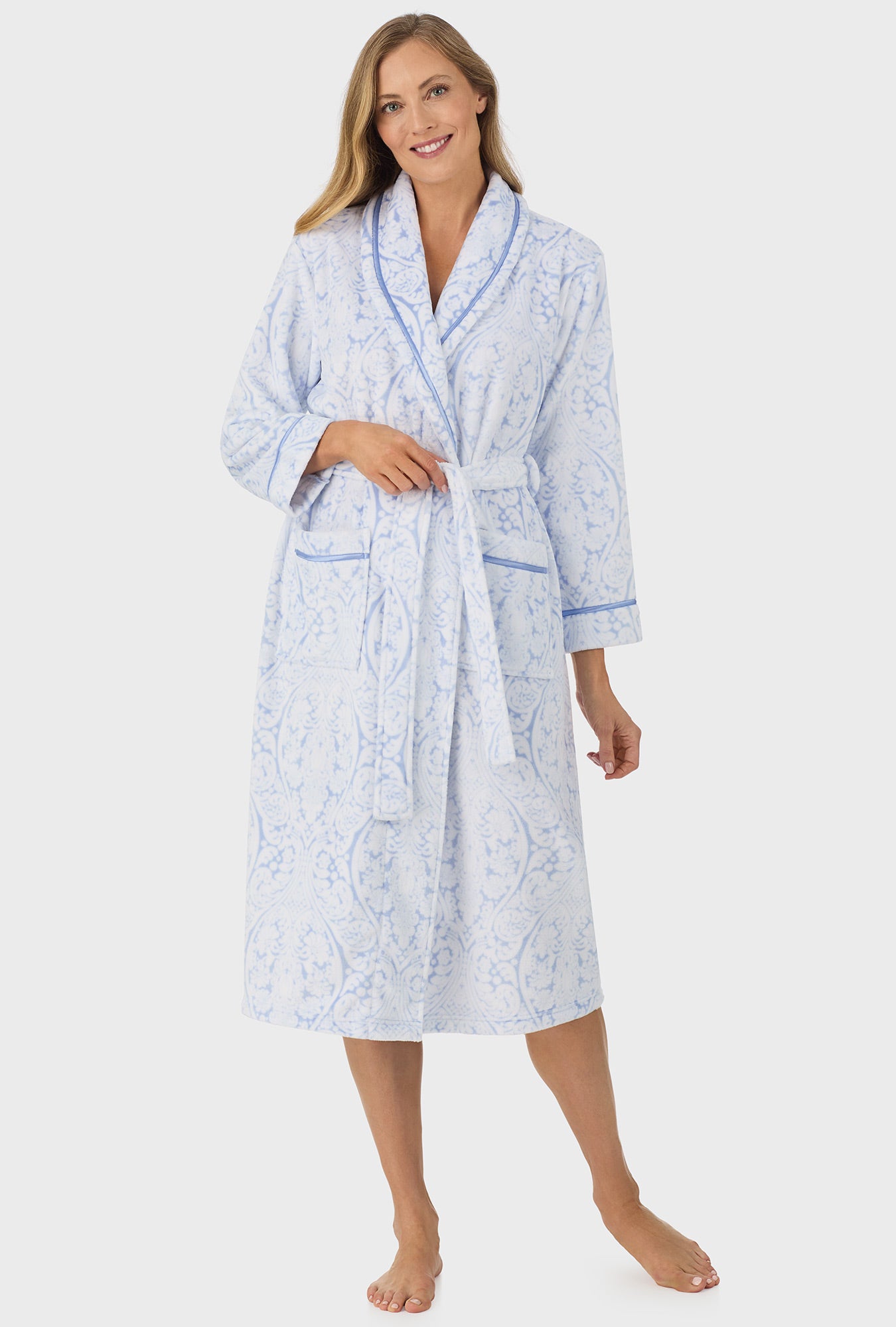 A lady wearing blue wrap robe with blue damask scroll print.