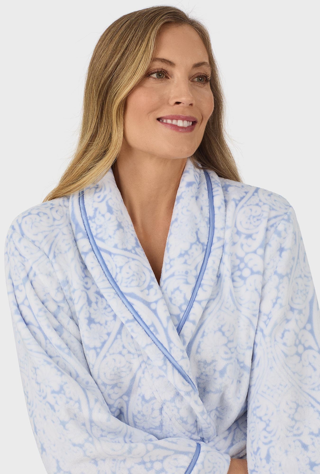 A lady wearing blue wrap robe with blue damask scroll print.