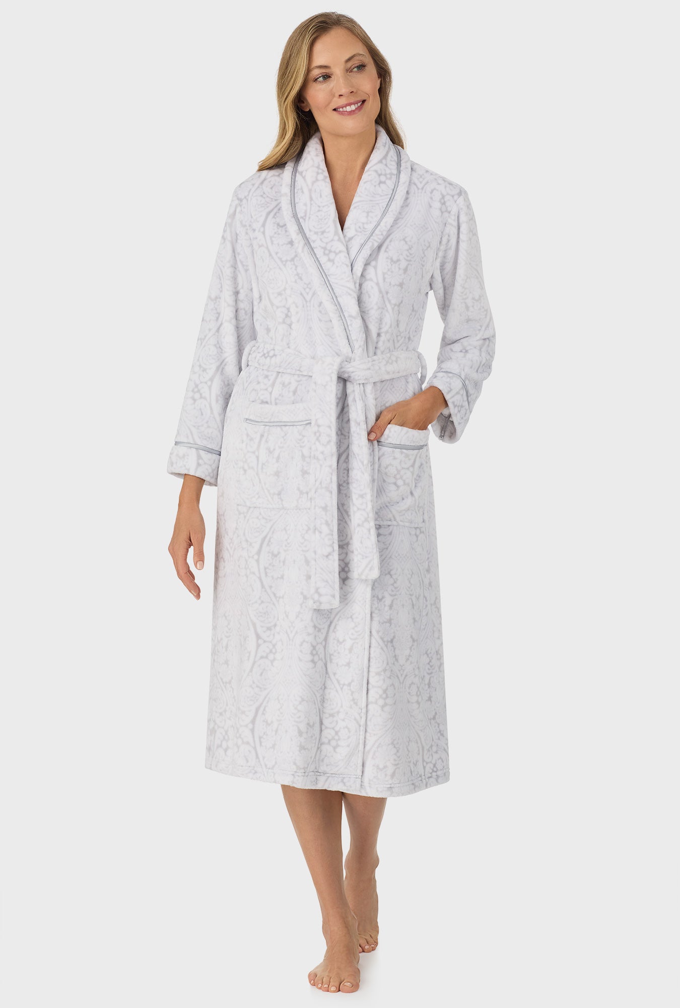 A lady wearing grey long sleeve wrap robe with white grey damask scroll print.