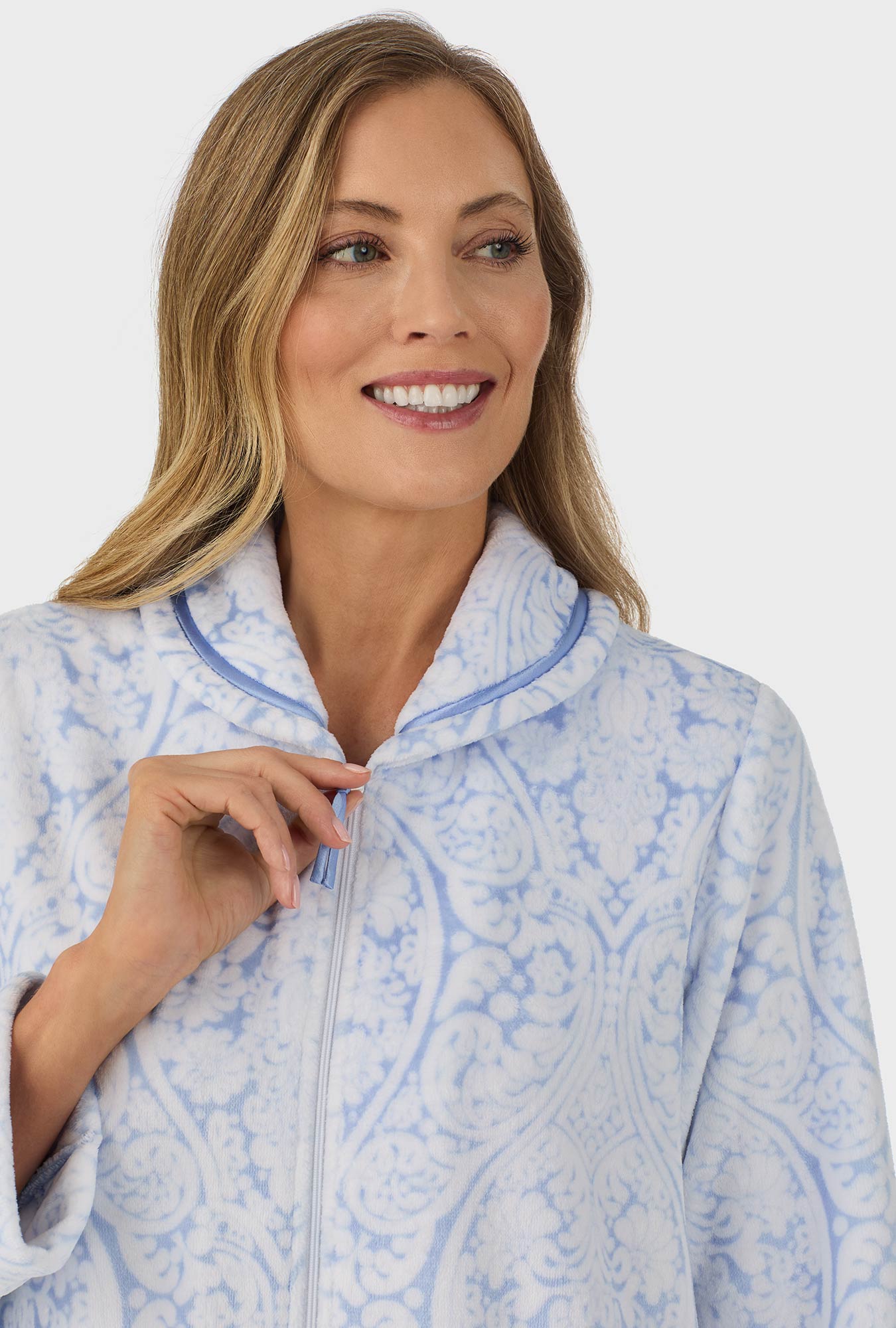 A lady wearing blue long sleeve zipper robe with blue damask scroll print.