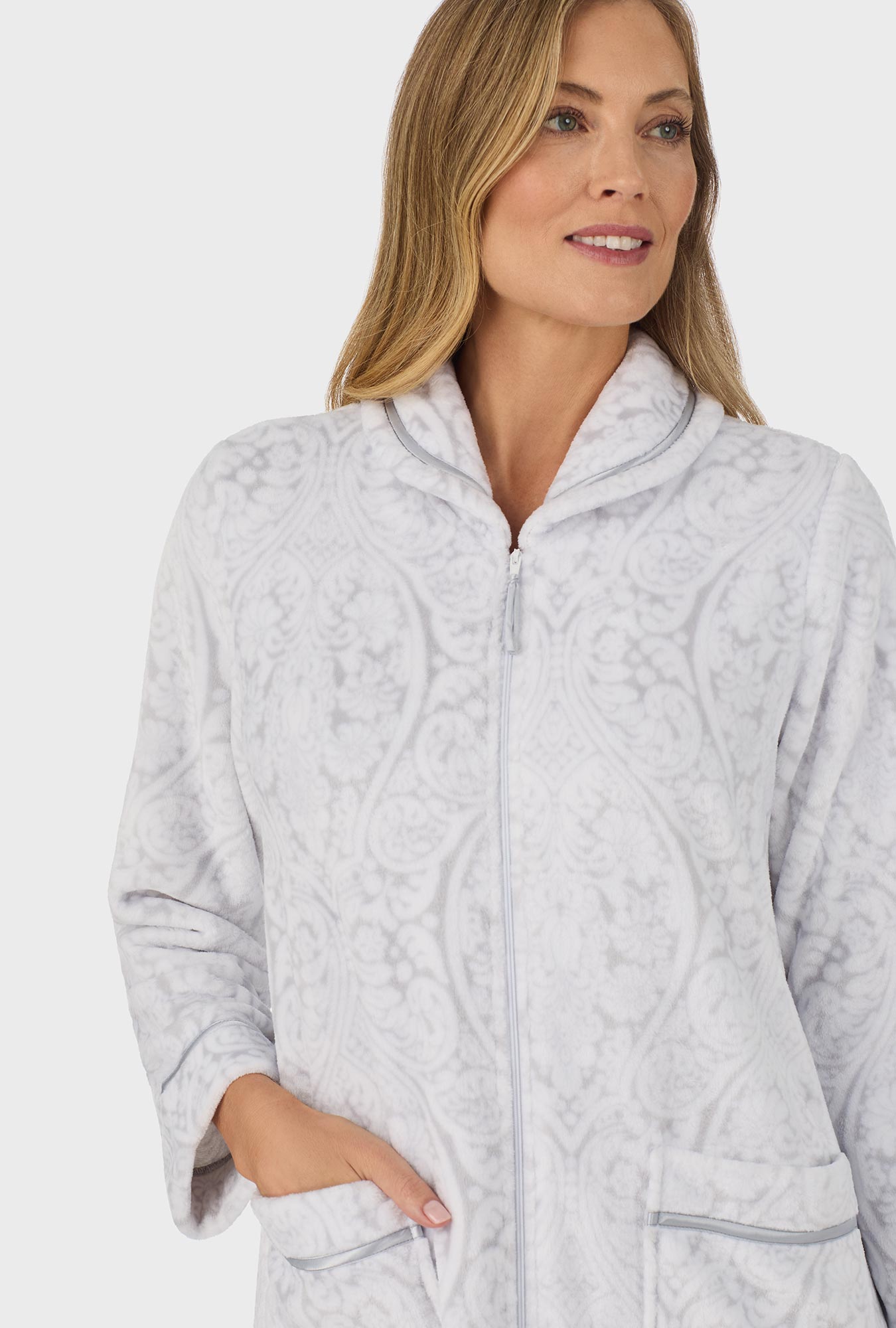 A lady wearing grey long sleeve zipper robe with white grey damask scroll print.