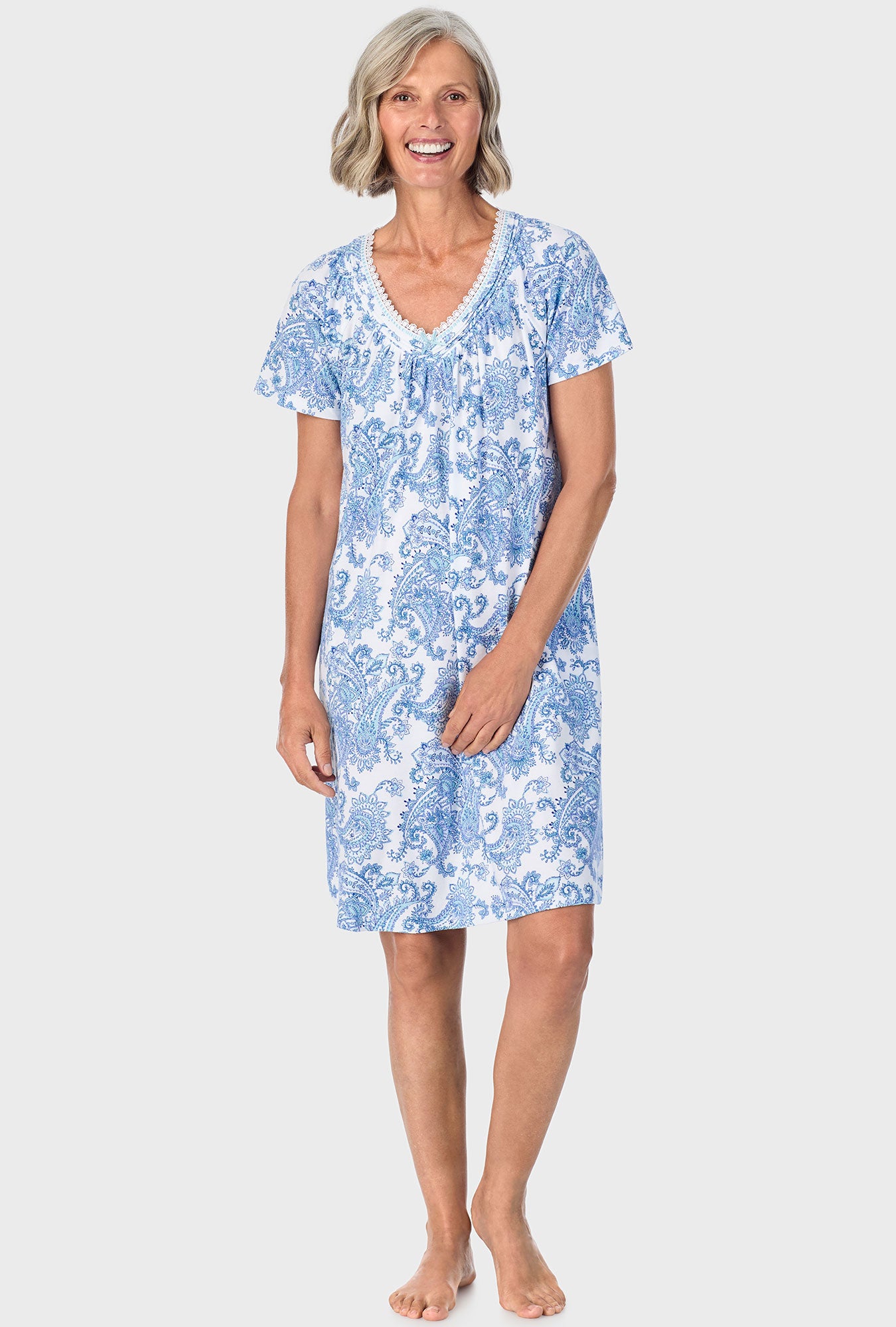 A lady wearing blue short sleeve sleepshirt with cool multi paisley print.