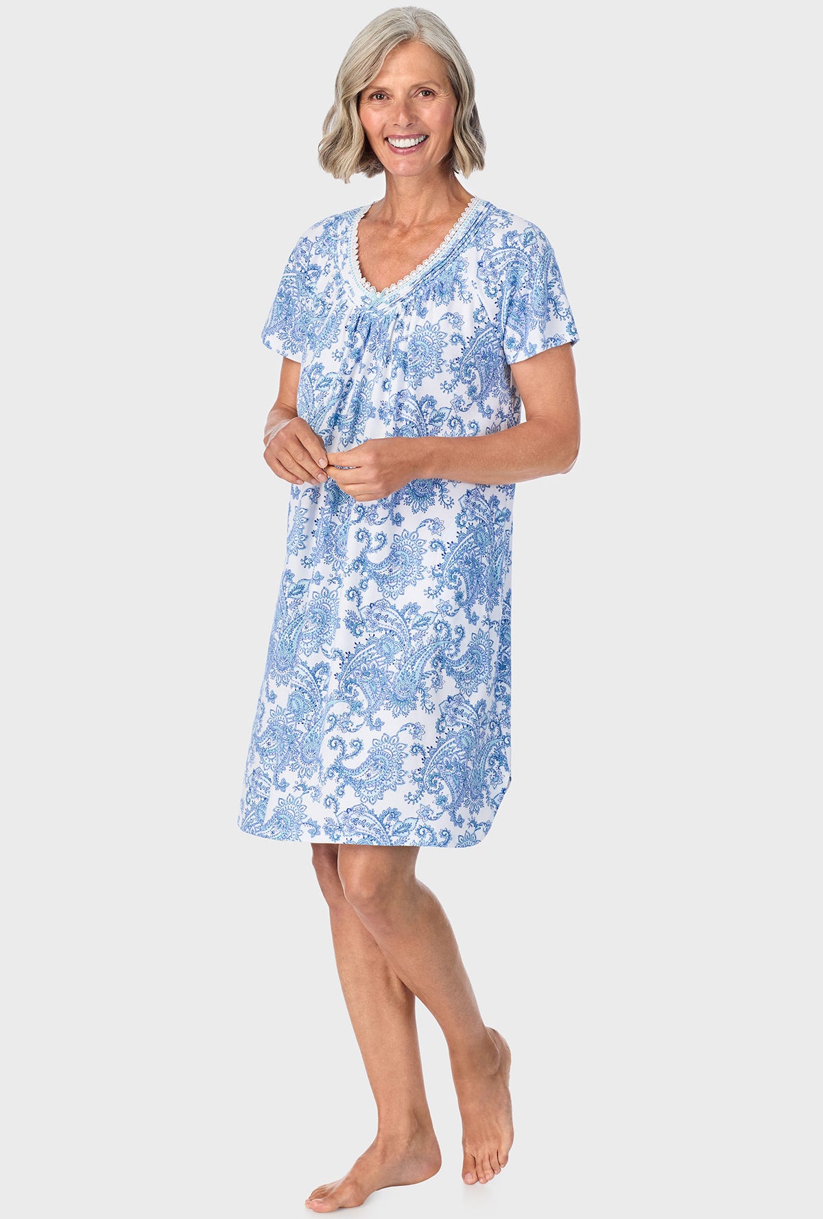 A lady wearing blue short sleeve sleepshirt with cool multi paisley print.