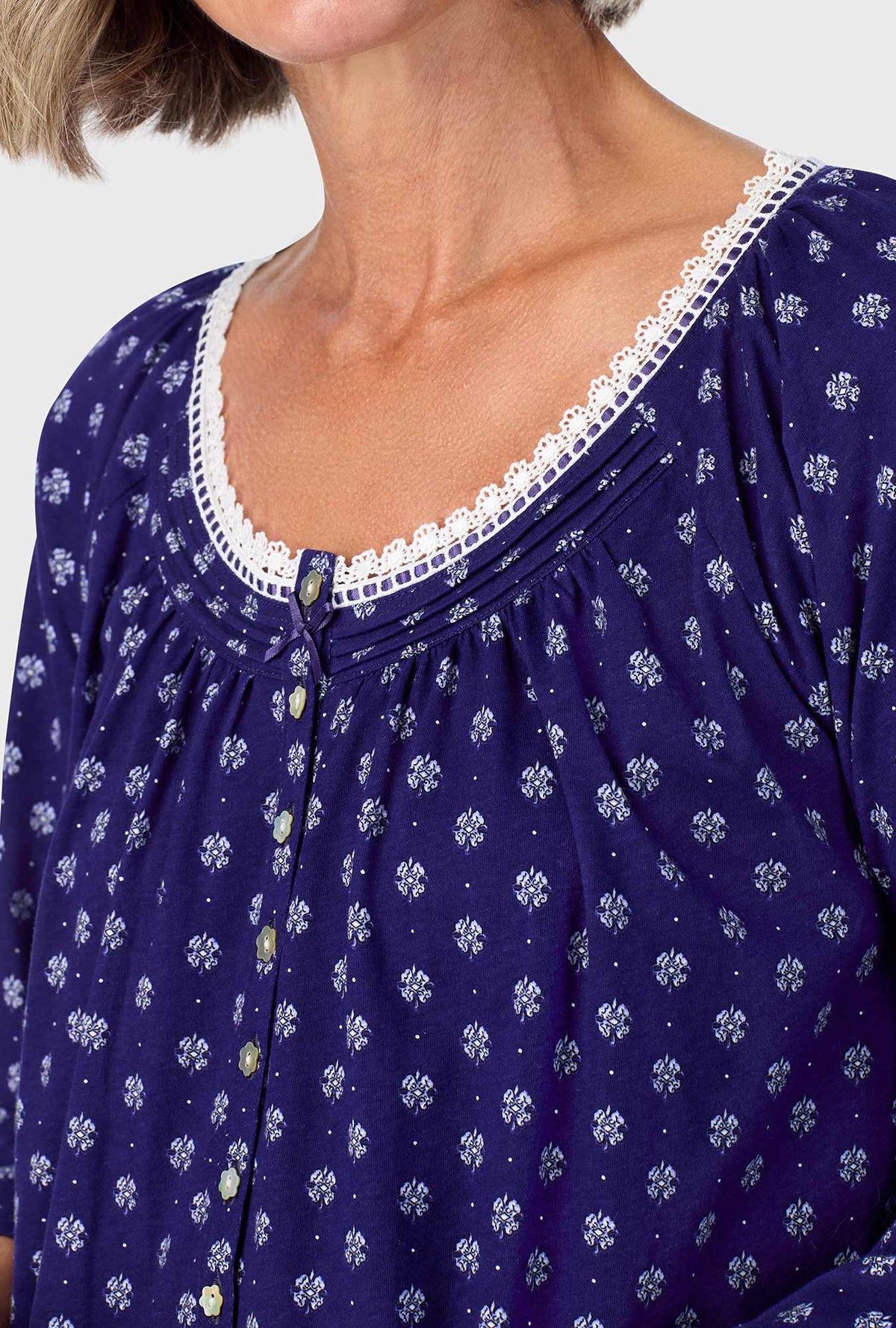 A lady wearing navy quarter sleeve nightgown with navy geo print.